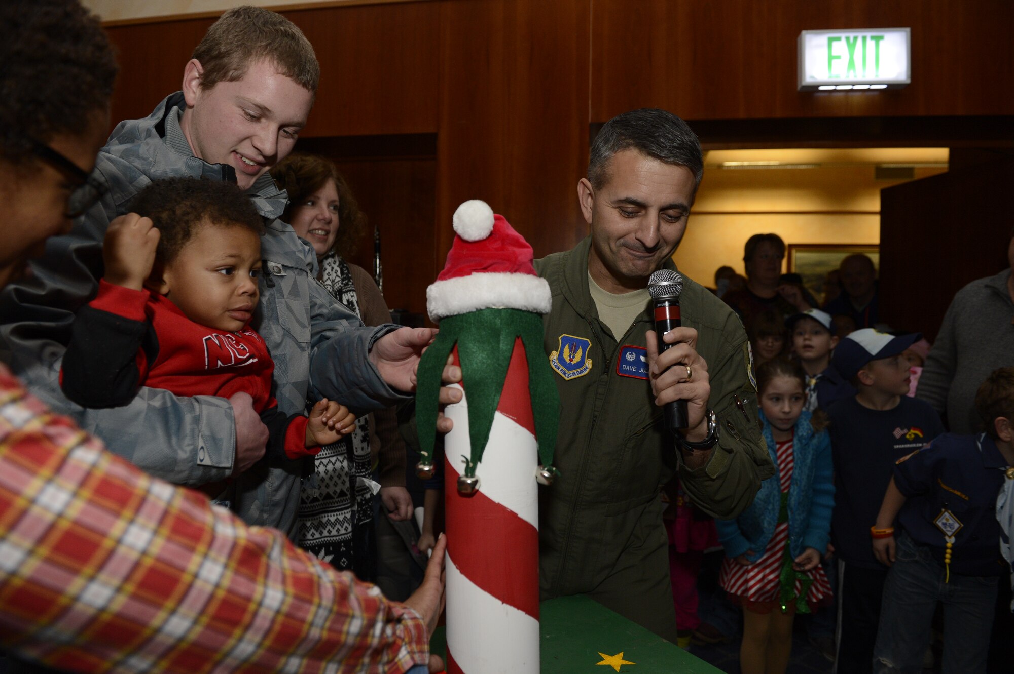 SPANGDAHLEM AIR BASE, Germany – U.S. Air Force Col. David Julazadeh, 52nd Fighter Wing commander, aided by Asher Perry, son of Cecilia Perry and deployed Capt. John Perry II, 726th AMS aerial port flight commander, flips a switch to light the Spangdahlem holiday tree during the tree lighting ceremony at Club Eifel Dec. 5, 2013. The city of Spangdahlem donated the tree to the air base. (U.S. Air Force photo by Staff Sgt. Christopher Ruano/Released)