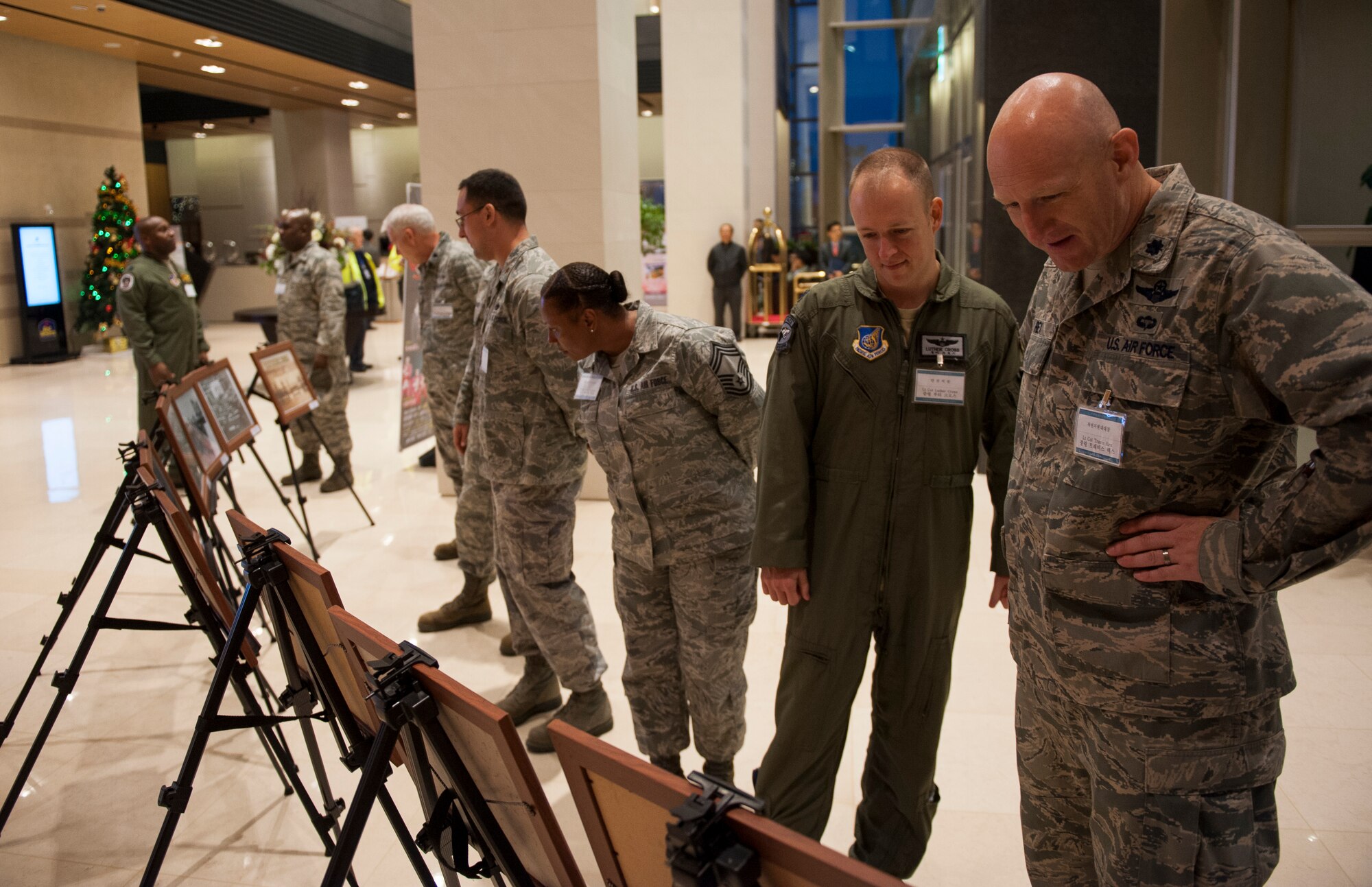 Leadership from the 8th Fighter Wing view historical photos of Kunsan and the local community during a community event in Gunsan City, Republic of Korea, Dec. 5, 2013. The Korean and American Gunsan Alliance group held an event in recognition of the cooperation and support between the Gunsan community and Kunsan Air Base. (U.S. Air Force photo by Senior Airman Armando A. Schwier-Morales/Released)