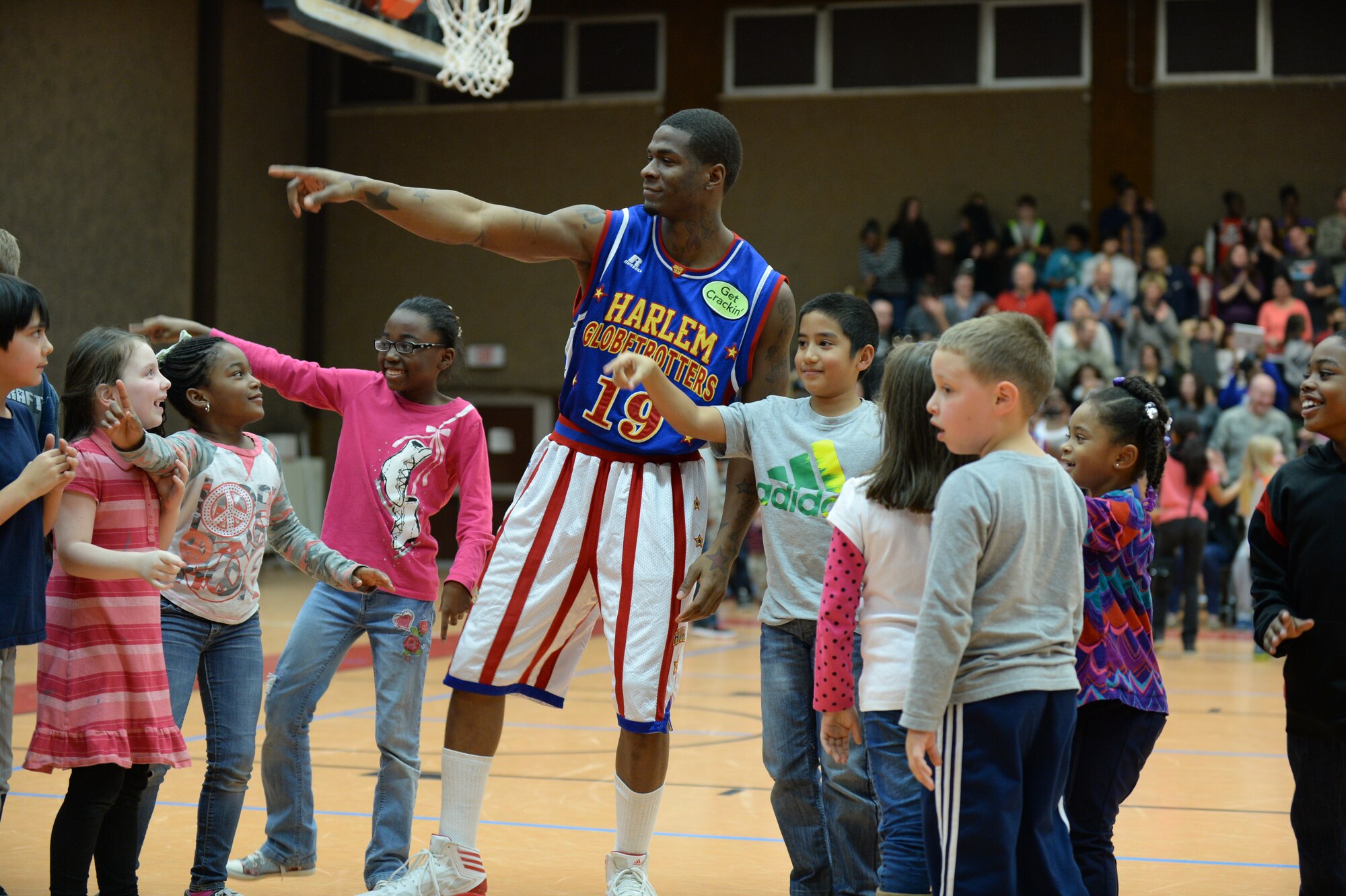 SPANGDAHLEM AIR BASE, Germany --- Flip, a player of the Harlem Globetrotters basketball team, leads children in a dance during a complimentary game at the Skelton Memorial Fitness Center Dec. 4, 2013. The Harlem Globetrotters called upon children in the audience to participate in certain moments throughout the game. (U.S. Air Force photo by Staff Sgt. Joe W. McFadden / Released)