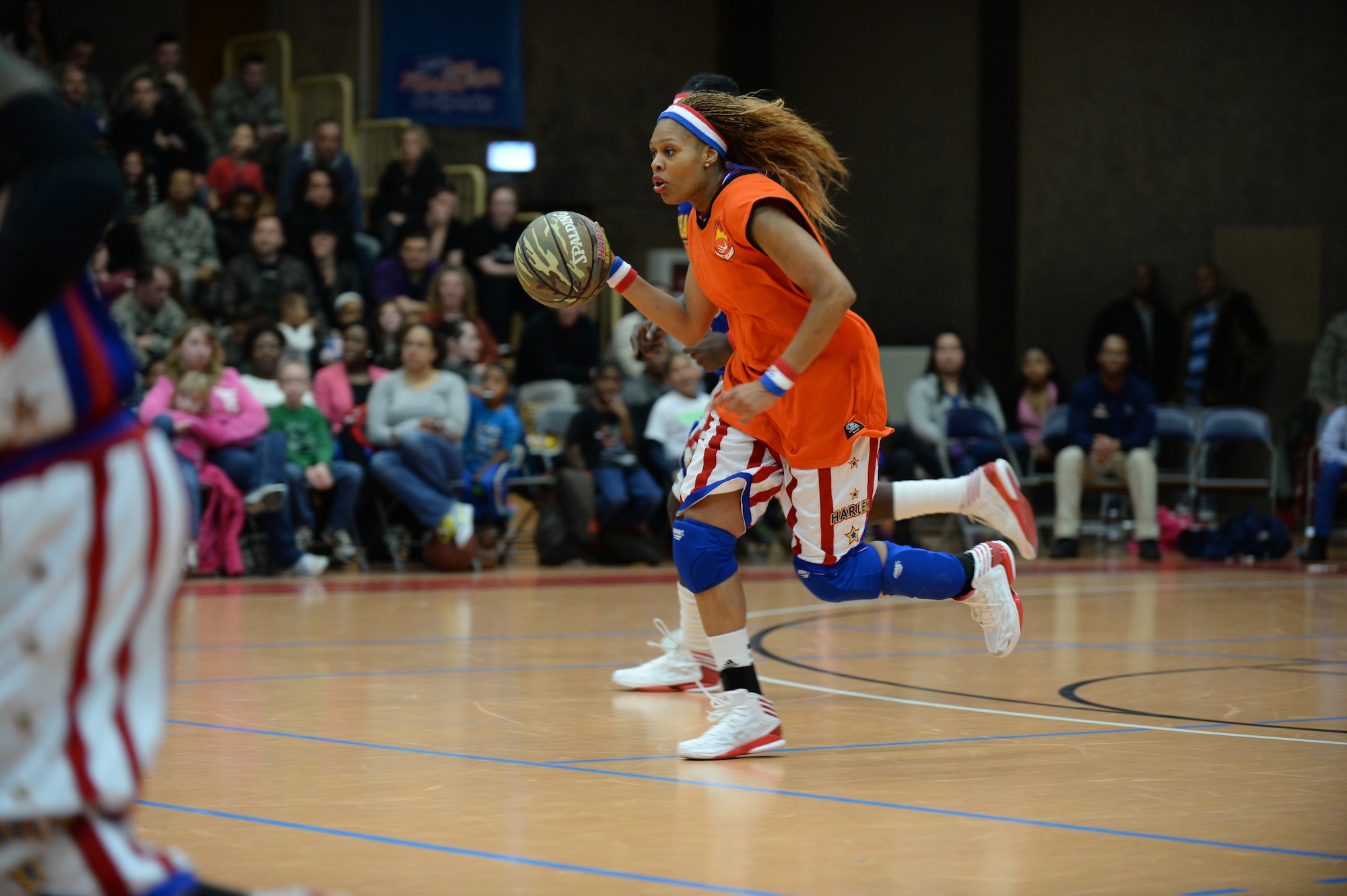 SPANGDAHLEM AIR BASE, Germany --- Sweet J, a player of the Harlem Globetrotters basketball team, drives a basketball down a court during a complimentary game at the Skelton Memorial Fitness Center Dec. 4, 2013. Sweet J is one of 12 female players in the franchise’s history. (U.S. Air Force photo by Staff Sgt. Joe W. McFadden / Released)