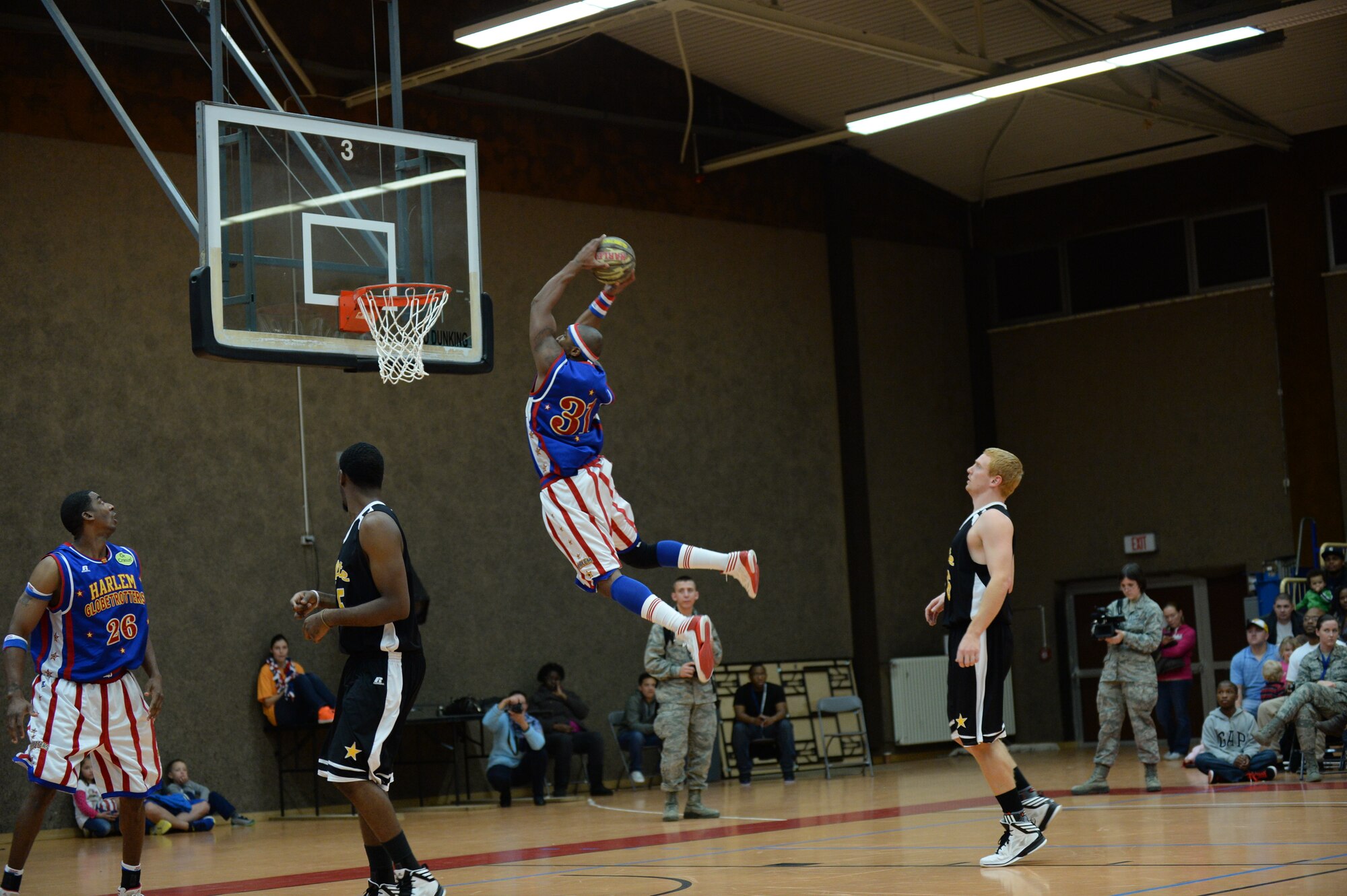SPANGDAHLEM AIR BASE, Germany --- Hammer, a member of the Harlem Globetrotters basketball team, prepares to dunk a basketball during a complimentary game at the Skelton Memorial Fitness Center Dec. 4, 2013. More than 1,000 Saber Airmen and their families attended in the event sponsored by Navy Entertainment and Armed Forced Entertainment and hosted by the 52nd Force Support Squadron. (U.S. Air Force photo by Staff Sgt. Joe W. McFadden / Released)