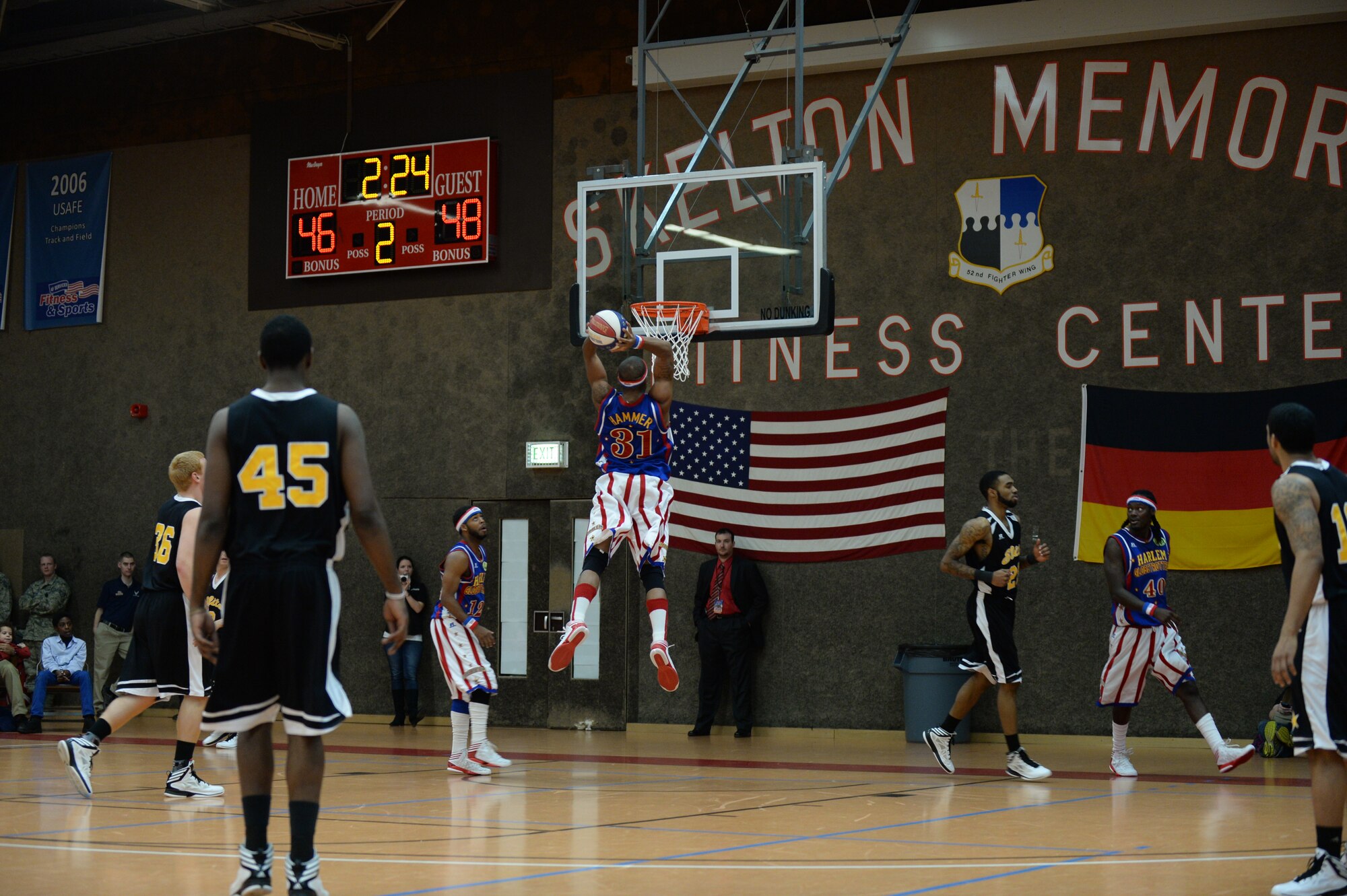 SPANGDAHLEM AIR BASE, Germany --- Hammer, a member of the Harlem Globetrotters basketball team, prepares to dunk a basketball during a complimentary game at the Skelton Memorial Fitness Center Dec. 4, 2013. The Globetrotters performed both a basketball game and family entertainment showcase during the event. (U.S. Air Force photo by Staff Sgt. Joe W. McFadden / Released)