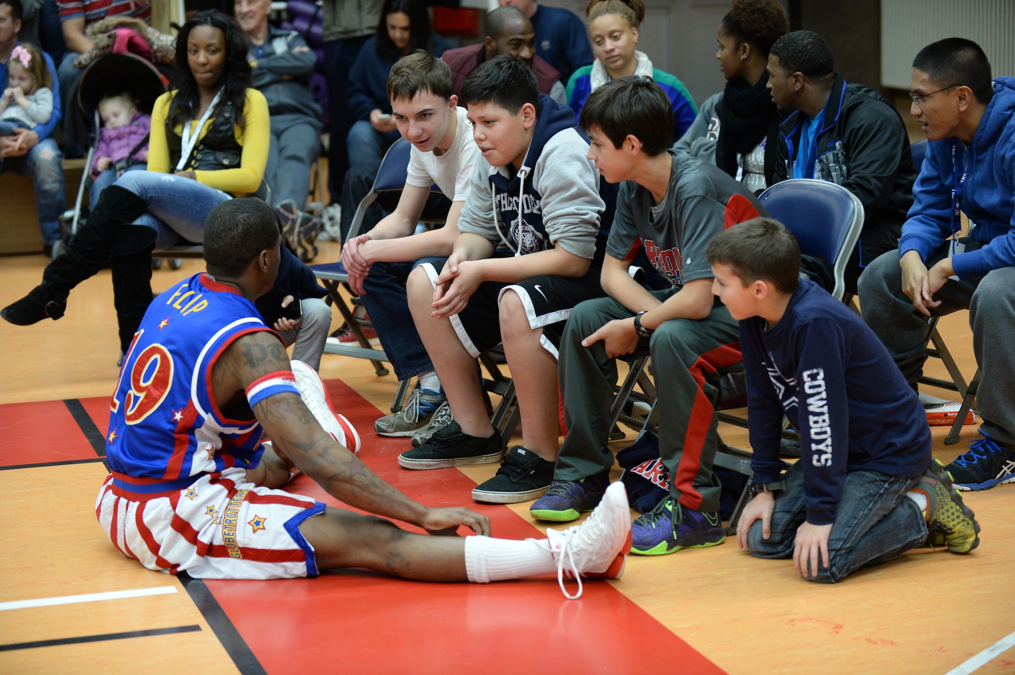 SPANGDAHLEM AIR BASE, Germany --- Flip, a player of the Harlem Globetrotters basketball team, speaks with audience members during a complimentary game at the Skelton Memorial Fitness Center Dec. 4, 2013. The Globetrotters signed autographs and posed for photos after defeating the rival International Elite 91-78. (U.S. Air Force photo by Staff Sgt. Joe W. McFadden / Released)