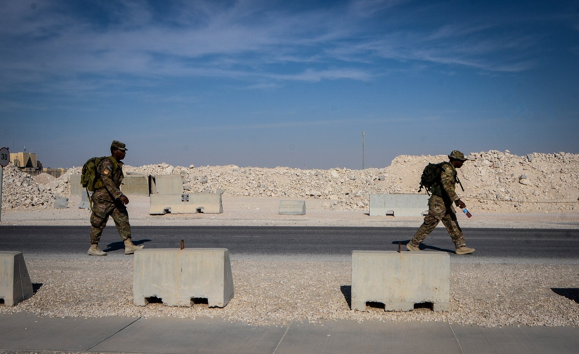 Tech. Sgt. Jarvais Parker (right) and Senior Airman Khary Cook march with 35-pound assault rucks during a 24-hour memorial ruck march at the 379th Air Expeditionary Wing in Southwest Asia, Dec. 6, 2013. Members from the 717th Expeditionary Air Support Operations Squadron participated in the march to remember the attacks on Pearl Harbor and to honor the fallen Tactical Air Control Party Airmen who gave the ultimate sacrifice. The ruck march started at 7:55 a.m. and will end Dec. 7th at 7:55 a.m., when the Japanese began the attack on the island of Oahu. The Airmen from the 717th EASOS are deployed from Joint Base Lewis-McChord, Wash. Parker hails from Houston, Texas, and Cook is a Brooklyn, N.Y. native. (U.S. Air Force photo/Senior Airman Jared Trimarchi)