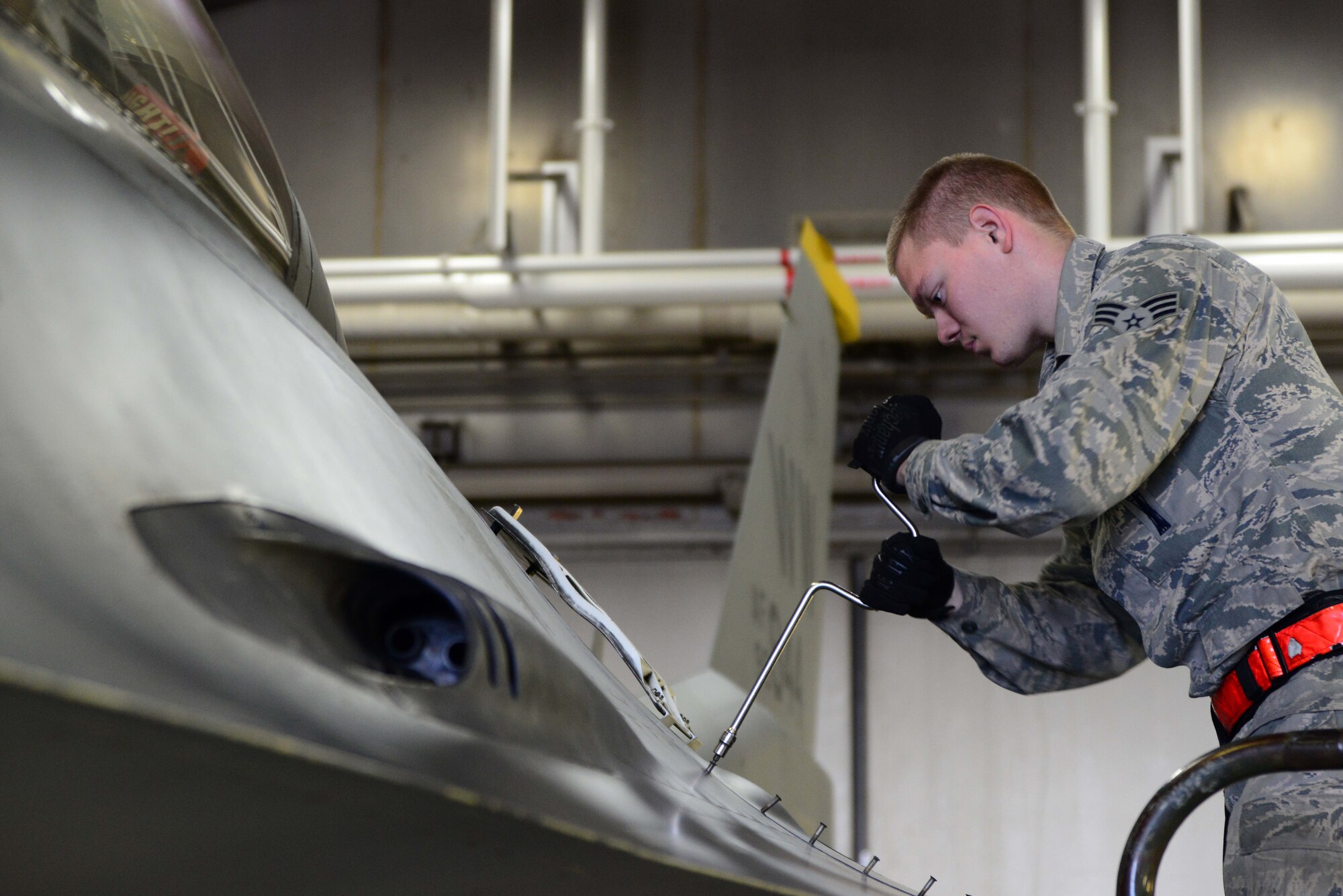 Senior Airman Ryan Skarin, 35th Aircraft Maintenance Squadron weapons systems technician, tightens the panel that holds an F-16 Fighting Falcon’s M61 A1 Gatling Gun at Misawa Air Base, Japan, Dec. 6, 2013. Weapons systems maintainers provide year-round maintenance to 44 F-16s assigned to Misawa AB. (U.S. Air Force photo by Senior Airman Derek VanHorn)