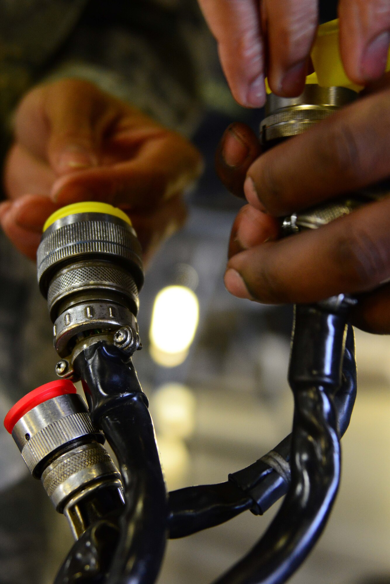 Airmen from the 35th Aircraft Maintenance Squadron apply connector caps to a center line pylon of an F-16 Fighting Falcon at Misawa Air Base, Japan, Dec. 6, 2013. Connector caps are applied to prevent any debris buildup around the pylon which connects fuel tanks, bombs and pods to the jet. (U.S. Air Force photo by Senior Airman Derek VanHorn)