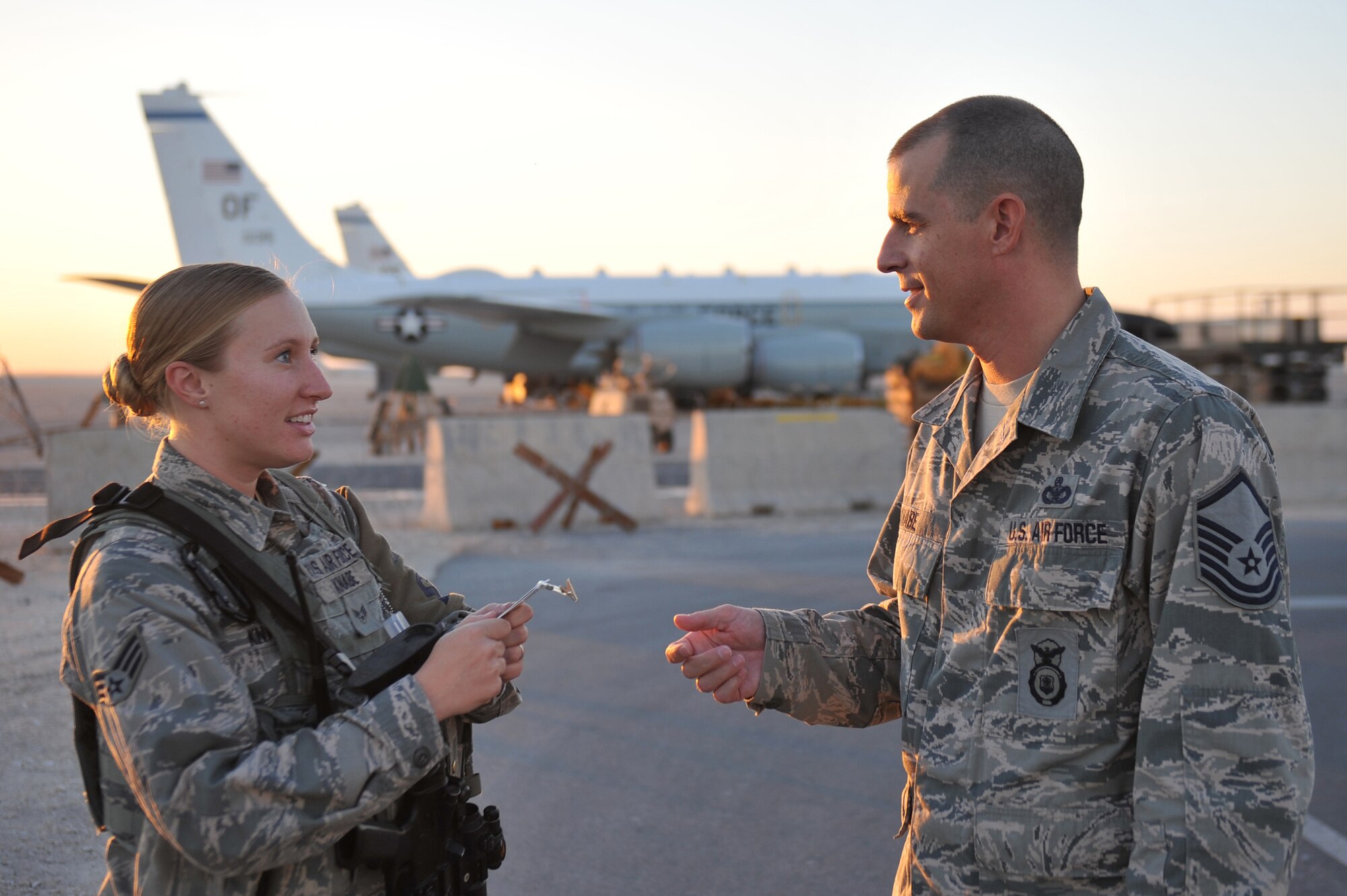 Senior Airman Robin Knabe checks Master Sgt. Christopher Knabe’s restricted area badge at the 379th Air Expeditionary Wing, Southwest Asia, Dec. 4, 2013. Robin was announced as PACAF’s Outstanding Security Forces Staff Level Airman of the Year and Christopher was announced as PACAF’s Col. Billy Jack Carter Award recipient. The couple is currently deployed together with Robin beginning her first deployment assigned to the 379th Expeditionary Security Forces Squadron as a base defender and Christopher is serving his fourth deployment as the 379th AEW Check Six NCO in charge. (U.S. Air Force photo/Master Sgt. David Miller)