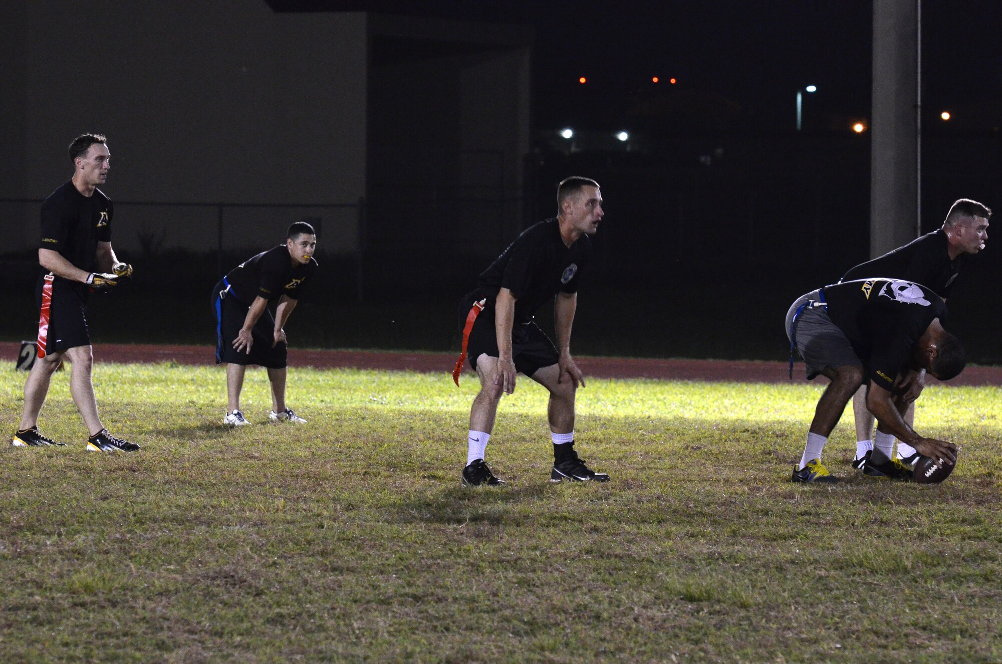 Players from 94th Army Air and Missile Defense Command prepare to play intramural flag football Dec. 4, 2013 on Andersen Air Force Base, Guam. 94th AAMDC practiced with Helicopter Sea Combat Squadron 25 to prepare for future games. (U.S. Air Force photo by Airman 1st Class Mariah Haddenham/Released)