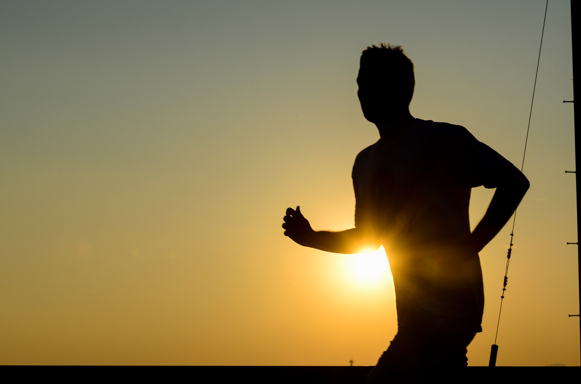 A runner passes by the setting sun during an Ugly Sweater 5k run at Yokota Air Base, Japan, Dec. 5, 2013. More than 80 runners participated in the event. (U.S. Air Force photo by Senior Airman Cody H. Ramirez)