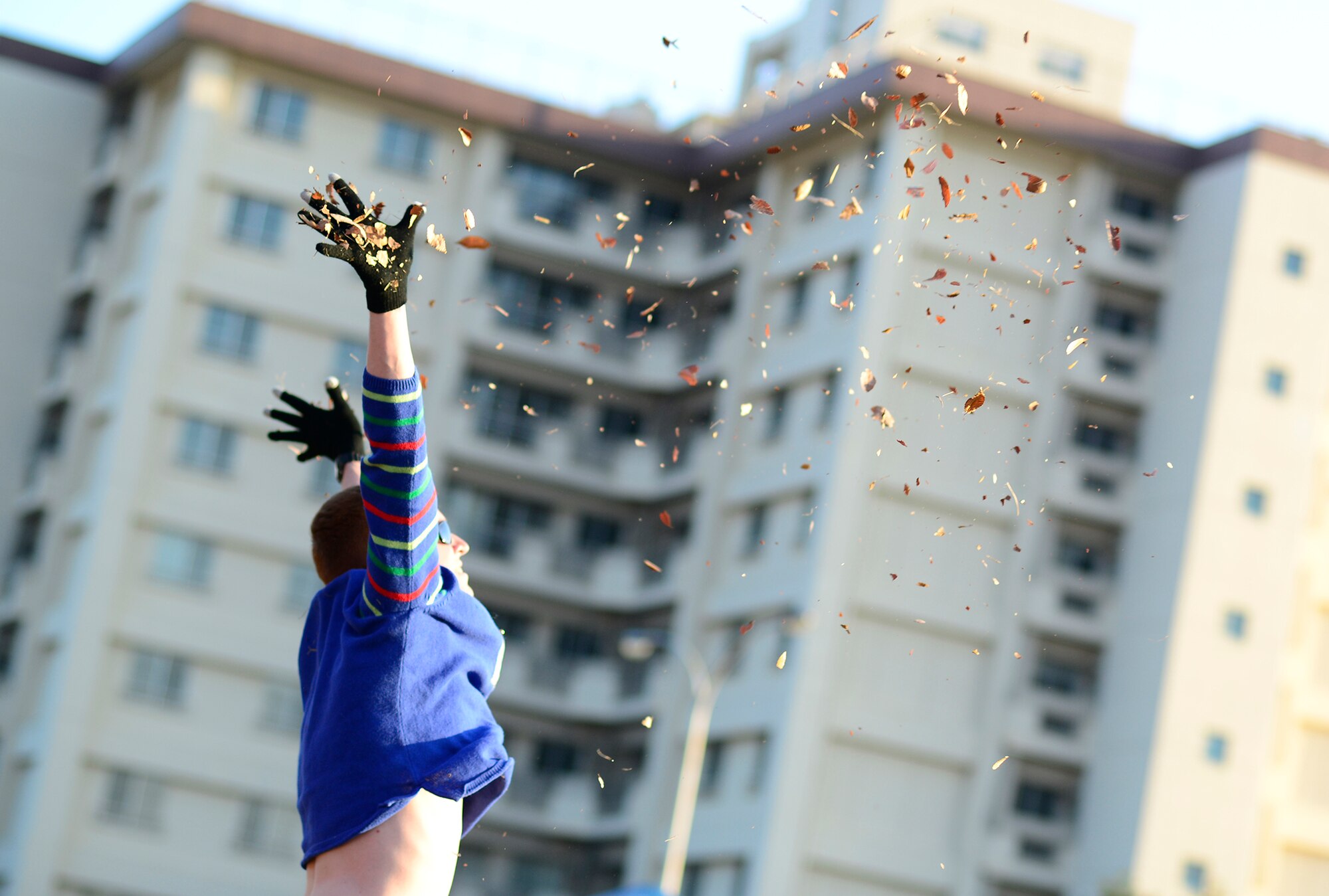 Senior Airman Witten Bolte, 374th Aircraft Maintenance Squadron crew chief, throws leaves into the air during warm-up ‘burpees’ before an Ugly Sweater 5k run at Yokota Air Base, Japan, Dec. 5, 2013. The 5k run brought more than 80 community members together to share holiday spirits. (U.S. Air Force photo by Senior Airman Cody H. Ramirez)