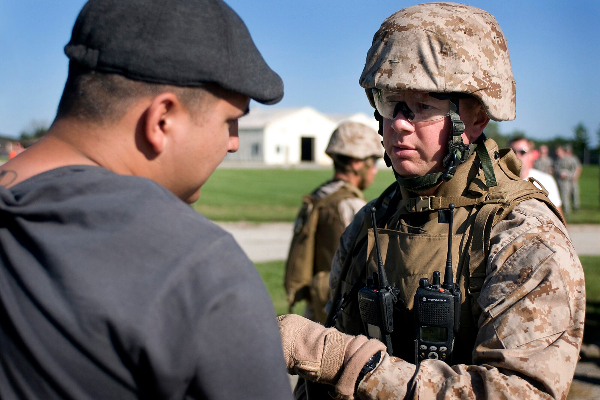U.S. Marine Capt. Scott Monroe, 4th Marine Logistics Group Forward East, talks with a simulated foreign national during a joint, mass-casualty exercise held at Grissom Air Reserve Base, Ind., Aug. 4, 2013. During the exercise Monroe led a joint U.S. force that was tasked with providing security to a democratic voting process in a foreign nation. (U.S. Air Force photo/Tech. Sgt. Mark R. W. Orders-Woempner) 