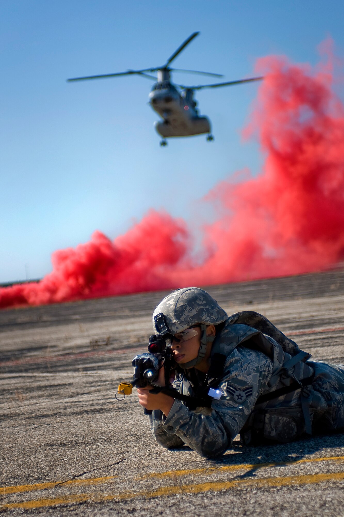 U.S. Air Force Senior Airman Krystal Collier, 434th Security Forces Squadron fire team member, secures a landing zone for a U.S. Marine CH-46 Sea Knight as the helicopter lands in the background during a joint, mass-casualty exercise held at Grissom Air Reserve Base, Ind., Aug. 4, 2013. Collier and other 434th SFS Airmen embedded with U.S. Marines and Air Force explosive ordinance disposal units during an initial assault to secure a voting location in a simulated overseas nation. (U.S. Air Force photo/Tech. Sgt. Mark R. W. Orders-Woempner) 