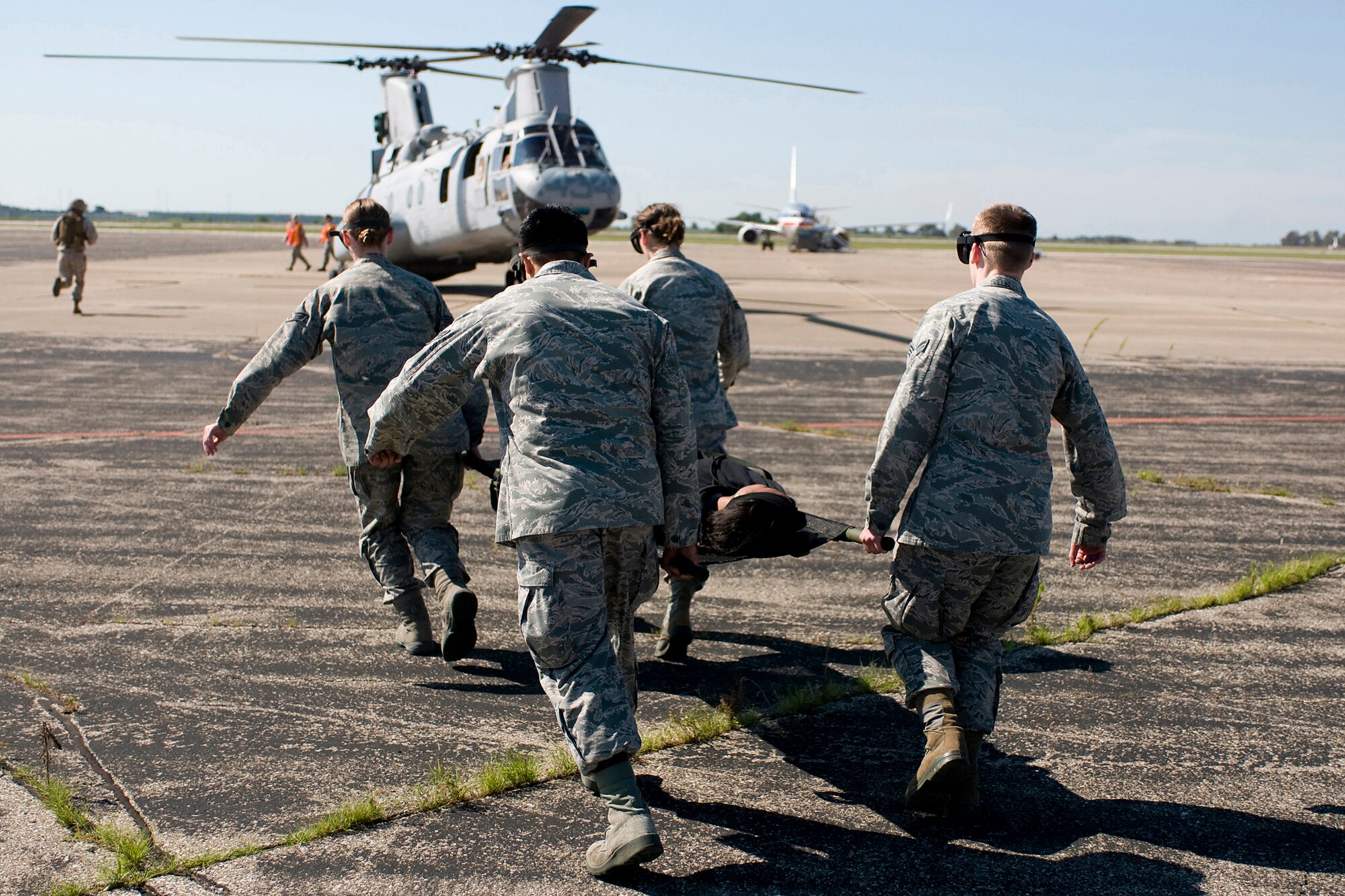 U.S. Air Force Airmen from the 434th Aerospace Medicine Squadron transport a simulated injured civilian to a U.S. Marine CH-46 Sea Knight helicopter during a joint, mass-casualty exercise held at Grissom Air Reserve Base, Ind., Aug. 4, 2013. During the exercise, which was held at a simulated overseas location, Airmen used their combat life-saving skills as they teamed up with Marines from Grissom's Detachment One, Communication Company, Combat Logistics Regiment 45, 4th Marine Logistics Group. (U.S. Air Force photo/Tech. Sgt. Mark R. W. Orders-Woempner)