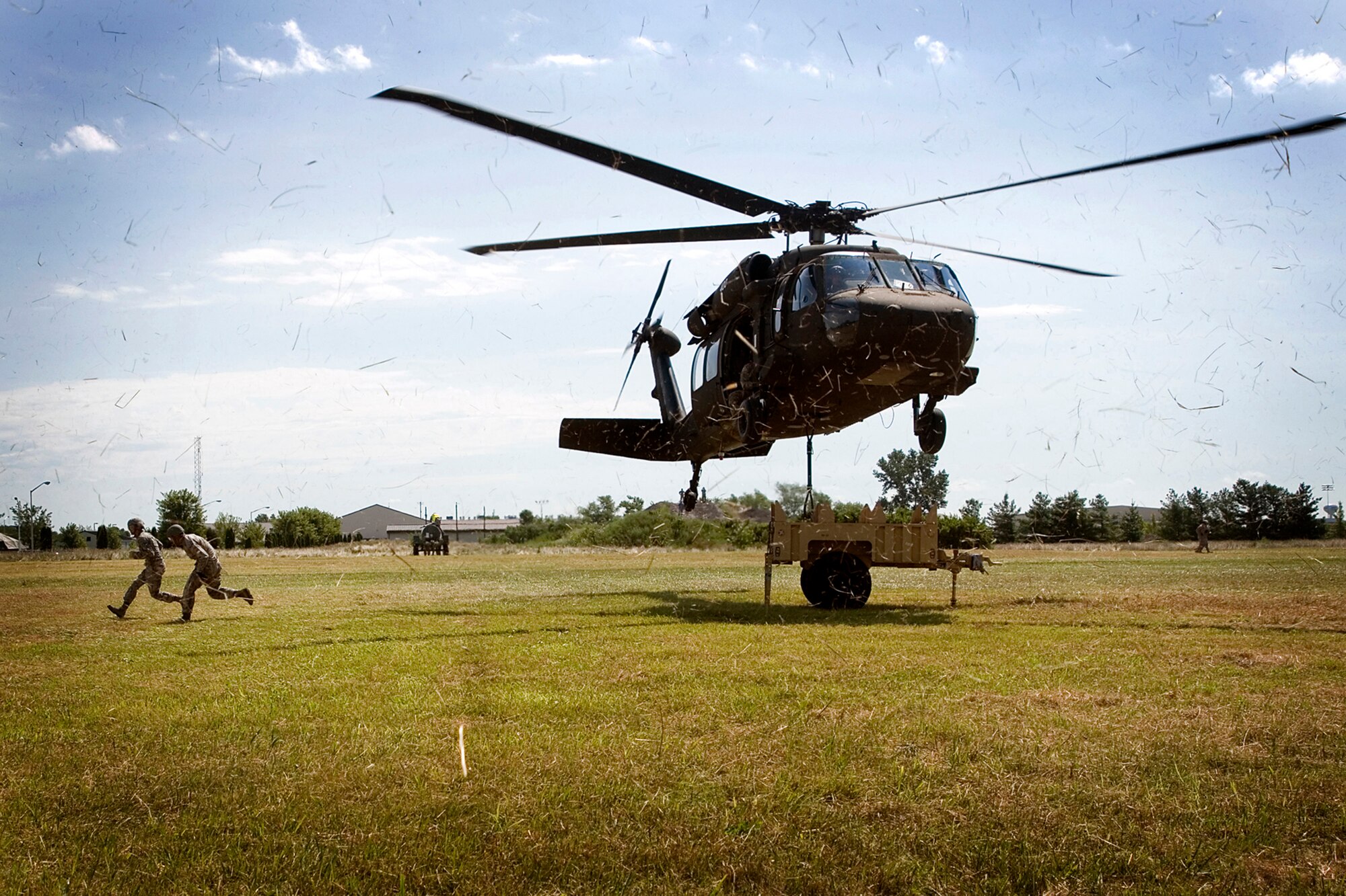 Air Force reservists from the 434th Force Support Squadron make their way from under a U.S. Army Reserve UH-60 Black Hawk helicopter after hooking a small trailer to the hovering aircraft for transport during a joint training exercise held at Grissom Air Reserve Base, Ind., July 23, 2013. The sling load training provided realism to the unit’s combat support mission. (U.S. Air Force photo/Tech. Sgt. Douglas Hays)