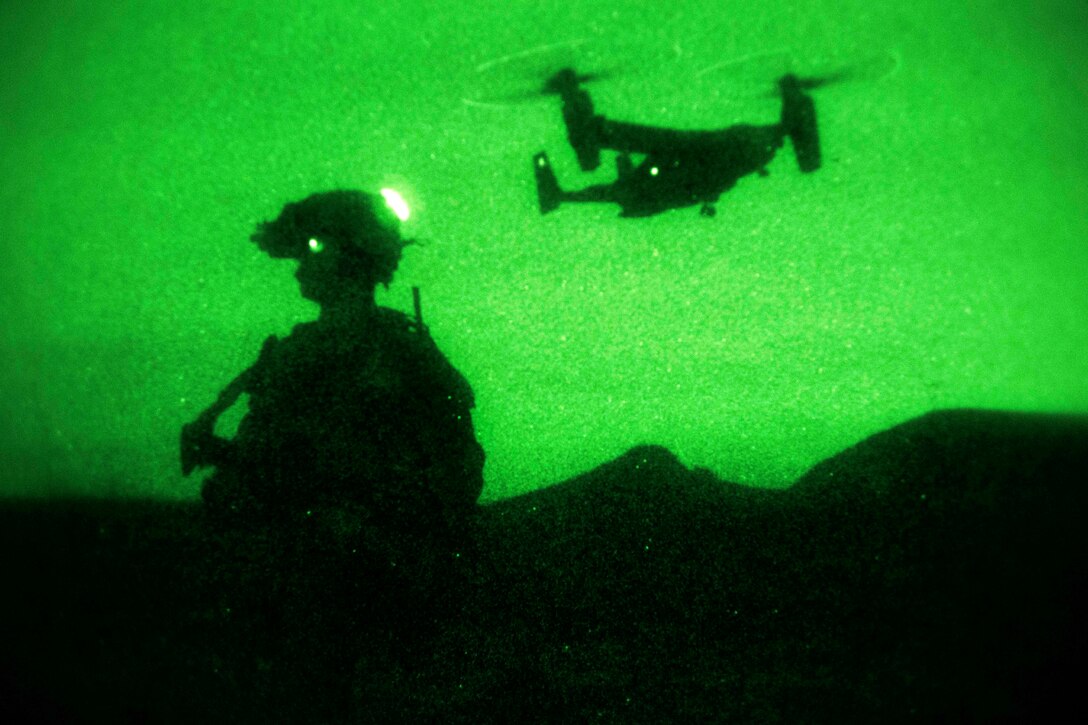 As seen through a night-vision device, a Marine provides security at the extraction point for a Marine Corps MV-22B Osprey while conducting a night raid, live-fire operations training on Camp Pendleton, Calif., Nov. 26, 2013.