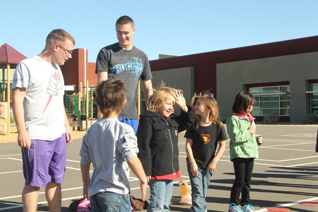 Cpl. Austin Worley, unmanned aerial vehicle operator, Unmanned Aerial Vehicle Squadron 1, and Lance Cpl. Jessy Holcomb, unmanned aerial vehicle operator, VMU-1, prepare to run alongside children at Joshua Tree Elementary during an adopt-a-school visit Dec. 4, 2013.


