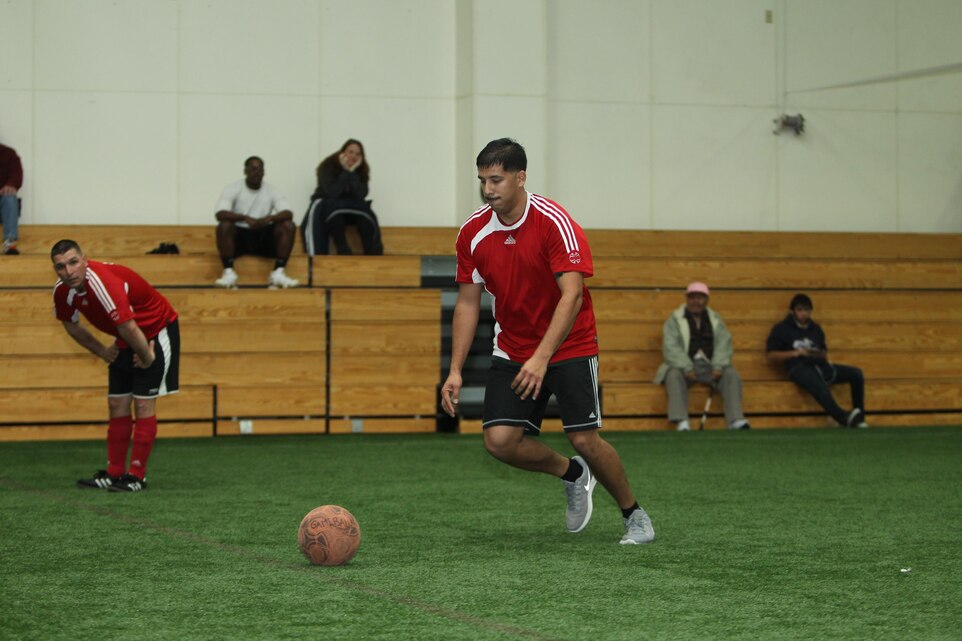 John Vasquez, soccer player, Tactical Training Exercise Control Group, maneuvers the playing field during an indoor soccer match against Headquarters Battalion at the East Gym Dec. 3, 2013.