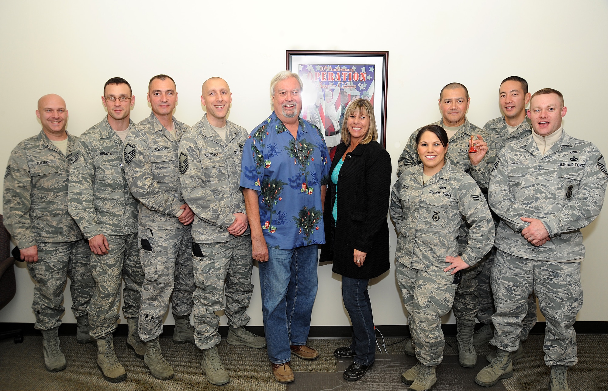 Volunteers and event coordinates gather for a group photo during the Operations Santa Claus telethon held at KPAM radio AM860, Portland, Ore., Dec. 6, 2013. Standing (From left to right) is Tech. Sgt. Shawn Potter, Staff Sgt. Matthew Meartz, Master Sgt. Jason Schroeder, Master Sgt. Matt Kochosky, Bob Miller host of the Bob Miller Show, Kimberly Pettina from  The Salvation Army, Senior Airman Lacey Bieker, Staff Sgt. Joseph Cubias, Senior Airman Yoshimura, and Master Sgt. Christopher Rich. The 142nd Fighter Wing volunteers helped raise over 47,000 dollars during the final day of The Salvation Army fund raising event, which helps support veterans of Oregon and Southwest Washington. (Air National Guard photo by Tech. Sgt. John Hughel, 142nd Fighter Wing Public Affairs/Released)