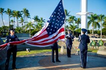 15th Wing Honor Guard members raise the U.S. flag at the December 7th Remembrance Ceremony on Hickam Field Dec. 7, 2013. The flag was flown at half- staff in honor of the 190 Airmen and civilians who lost their lives in the 1941 attack on the base.  In observance of its historical past, the ceremony took place at the flagpole in Atterbury Circle, a site which still boasts the original bullet holes and strafing marks from the attack. (U.S. Air Force photo/Staff Sgt. Terri Paden)