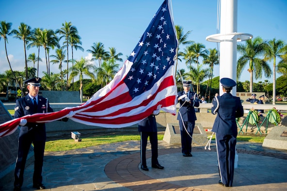 15th Wing Honor Guard members raise the U.S. flag at the December 7th Remembrance Ceremony on Hickam Field Dec. 7, 2013. The flag was flown at half- staff in honor of the 190 Airmen and civilians who lost their lives in the 1941 attack on the base.  In observance of its historical past, the ceremony took place at the flagpole in Atterbury Circle, a site which still boasts the original bullet holes and strafing marks from the attack. (U.S. Air Force photo/Staff Sgt. Terri Paden)
