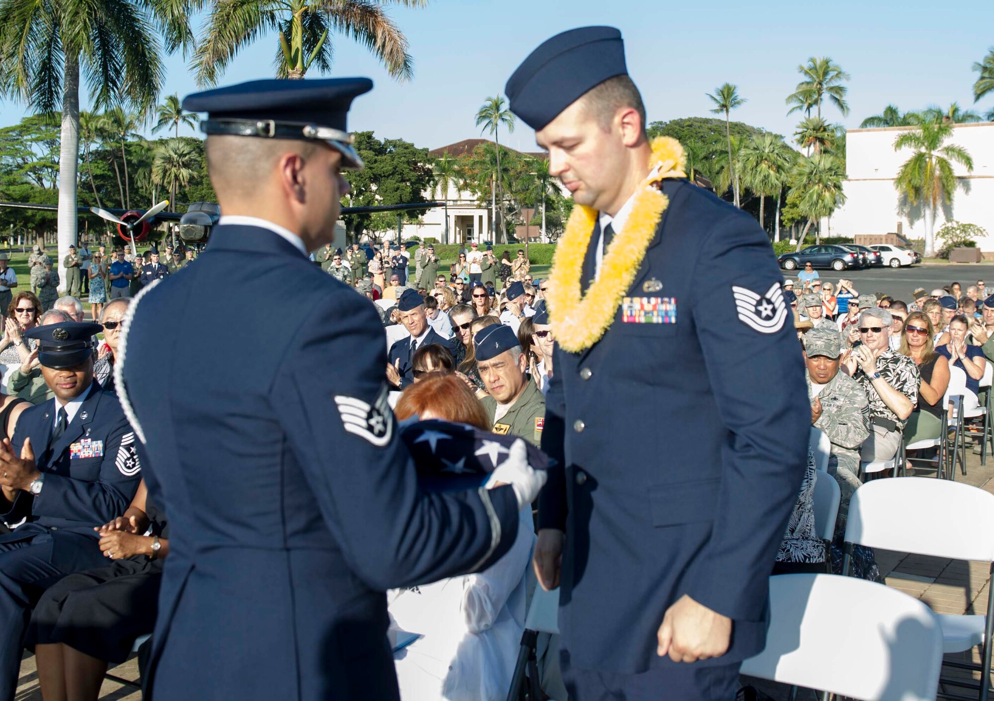 Tech. Sgt. Andrew Shepherd, right, 15th Aircraft Maintenance Squadron, is presented a flag by a Hickam Honor Guard member during the December 7th Remembrance Ceremony at Hickam Field, Dec. 7, 2013. Shepherd is the grandson of Hickam Field Attack survivor, Marion Shepherd, and received the flag in honor and recognition of his grandfather’s selfless service. Shepherd has been assigned to Hickam since August 2013 and served as a volunteer and honored guest at a Dec. 7, 1941, remembrance ceremony which paid homage to the 190 fallen men and women as well as the survivors.  (U.S. Air Force photo/Staff Sgt. Terri Paden)