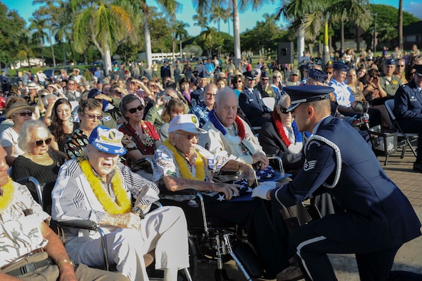 A Hickam Honor Guard member presents a U.S. flag to World War II veteran, Col. (ret ) Roy Bright, at the December 7th Remembrance Ceremony on Hickam Field, Dec. 7, 2013. Bright was a B-17 navigator assigned to Hickam Field at the time of the attack. At 99 years-old, Bright has never missed a December 7th  Remembrance Ceremony since 1946. The ceremony paid tribute to the 72nd Anniversary of the attack on Hickam Field Dec. 7, 1941, that claimed the lives of 190 Airmen and civilians. (U.S. Air Force photo/Staff Sgt. Terri Paden)