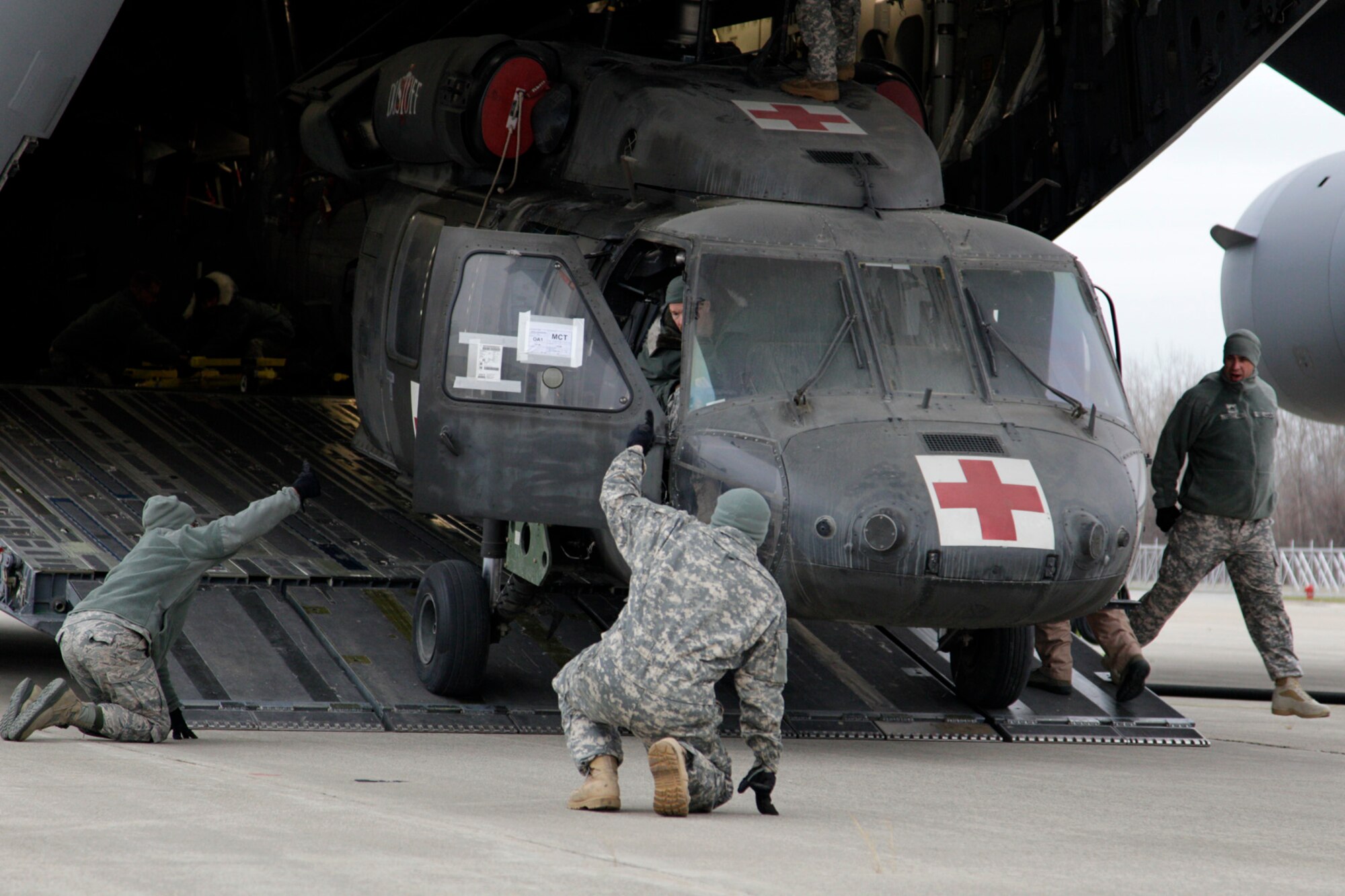 131206-Z-NJ721-048  A pair of UH-60 Medevac Black Hawk helicopters from the 3-238 General Support Aviation Battalion are unloaded from a C-17 Globemaster III at Selfridge Air National Guard Base, Mich., Dec. 6, 2013. after returning from service in Afghanistan.  The helicopters have returned from service in Afghanistan for maintenance and modifications which will upgrade them to a more comprehensive and modern medical care aircraft known as the HH-60. (U.S. Air National Guard photo by TSgt. Robert Hanet/Released)