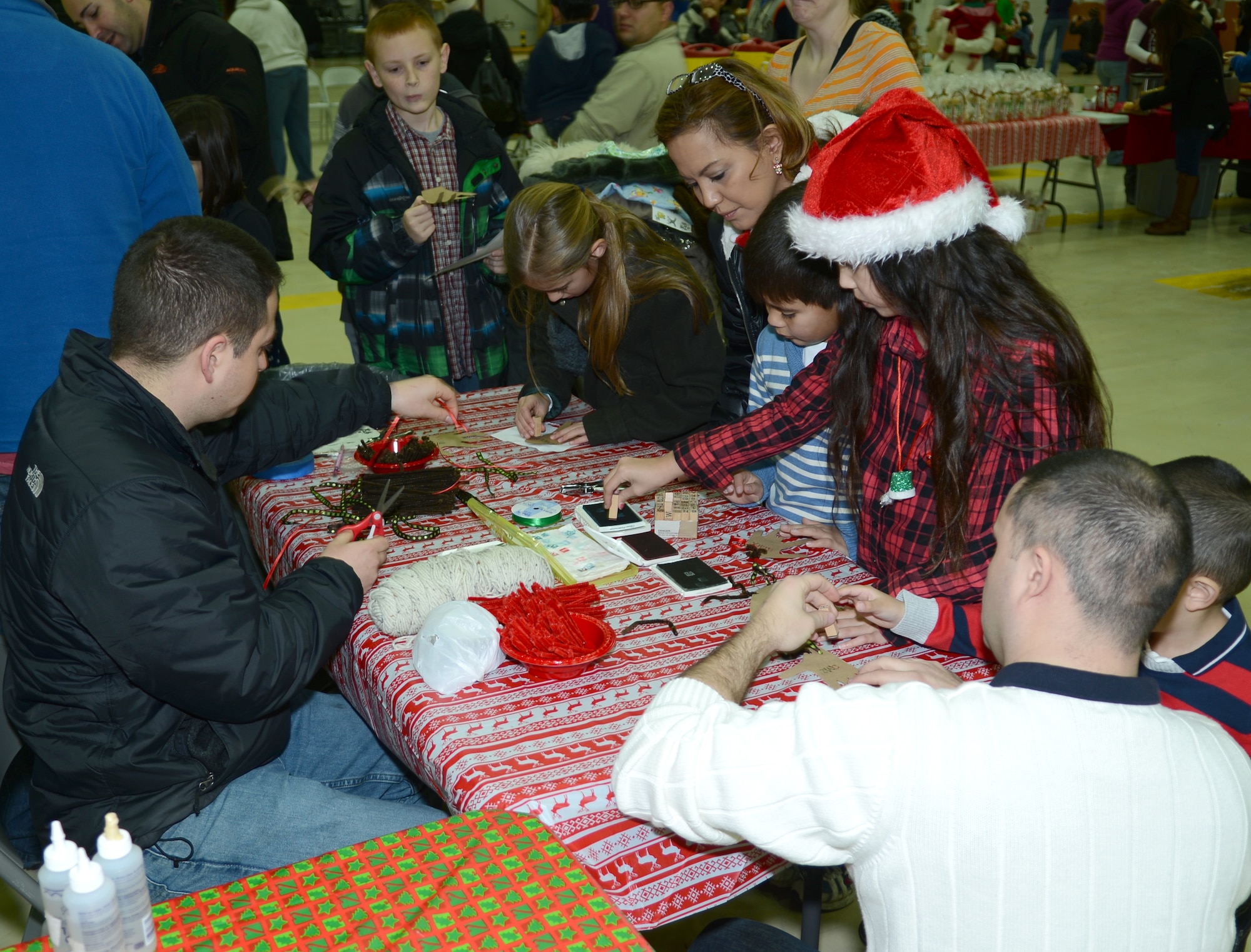Team Mildenhall children decorate Christmas tree ornaments during a children’s Christmas celebration Dec. 7, 2013, in hanger 803 on RAF Mildenhall, England. Children had the chance to meet Santa and his elves after he taxied to the hanger in a KC-135 Stratotanker. The event included games, food and crafts for Team Mildenhall members to participate in. (U.S. Air Force photo by Airman 1st Class Dillon Johnston/Released)