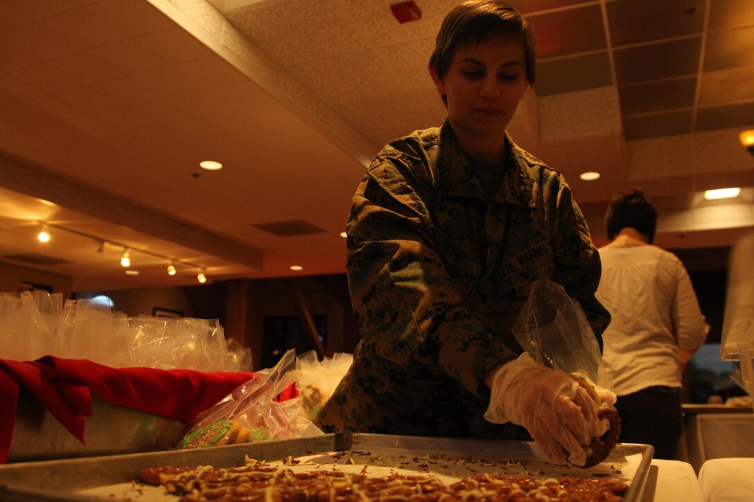 Cpl Ashley Hurd, supply, Exercise Support Division, Headquarters Battalion, organizes decorated pretzels into packages during the Treats for Troops event in the dining room of the Officer's Club Dec 3, 2013.