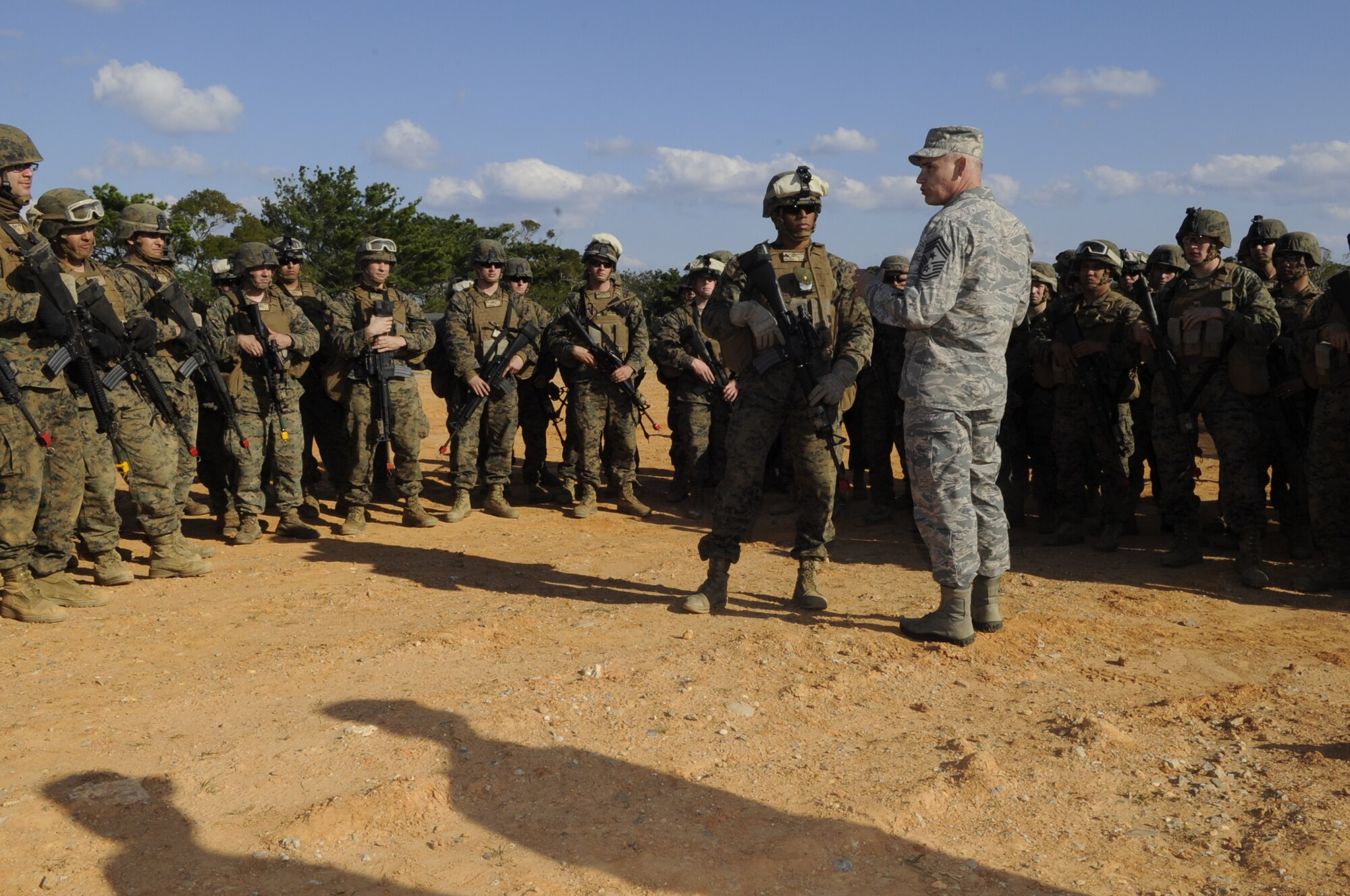 U.S. Air Force Chief Master Sgt. James Laurent, 5th Air Force command chief, coins U.S. Marine Corps Cpl. Anthony Wilder, Lima Battery, 3rd Battalion, 11th Marine Regiment NCO in charge of artillery, for going above and beyond the call of duty on Camp Hansen, Japan, Dec. 4, 2013. As a corporal, Wilder has stepped up and filled in the position of a staff sergeant and leads the artillery battery with precision. (U.S. Air Force photo by Senior Airman Marcus Morris)