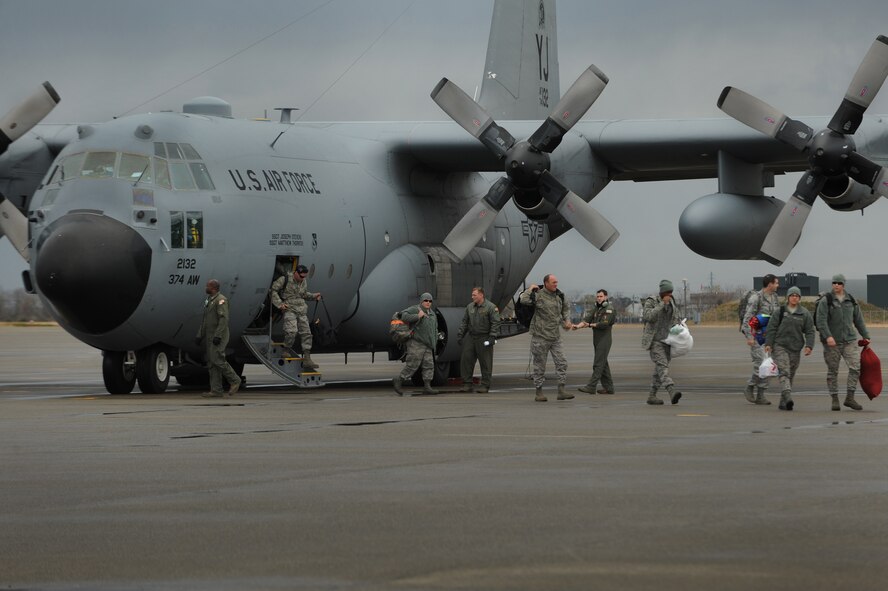 U.S. Air Force members from the 67th Fighter Squadron, Kadena Air Force Base, Japan, deplane a C-130 Hercules, on Komatsu Air Base, Japan, Dec. 7, 2013. The arrival of the C-130 is part of a week-long Aviation Training Relocation Program hosted by the Japanese Air Self Defense Force 6th Wing. (U.S. Air Force photo by Staff Sgt. Amber E. N. Jacobs)