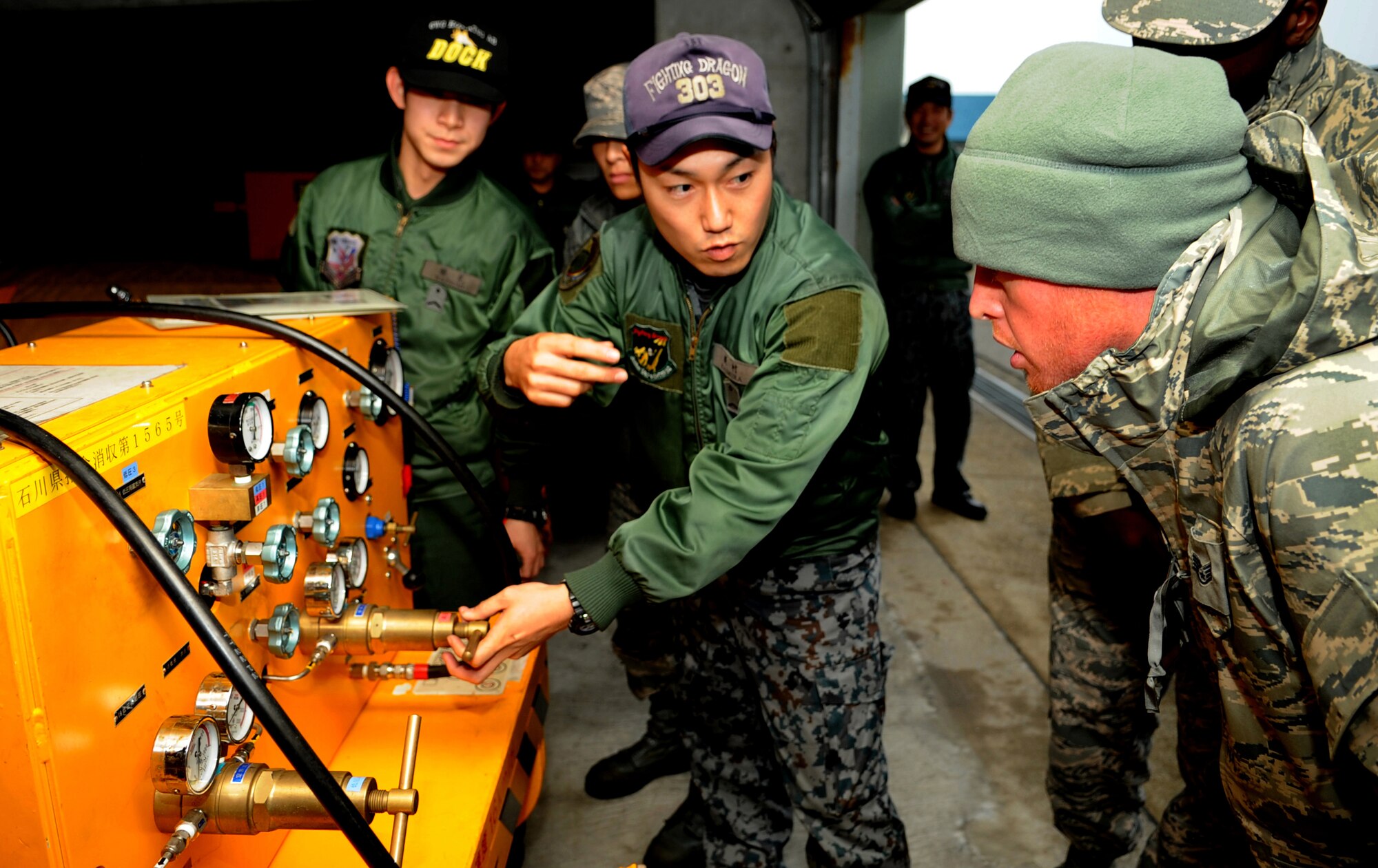 A member of the Japanese Air Self Defense Force explains how to use a lox cart to Staff Sgt. Don Wallace, 67th Fighter Squadron crew chief, on Komatsu Air Base, Japan, Dec. 6, 2013. The JASDF members trained U.S. Airmen on equipment in preparation for the arrival of six F-15 Eagles from Kadena Air Base. (U.S. Air Force photo by Staff Sgt. Amber E. N. Jacobs)