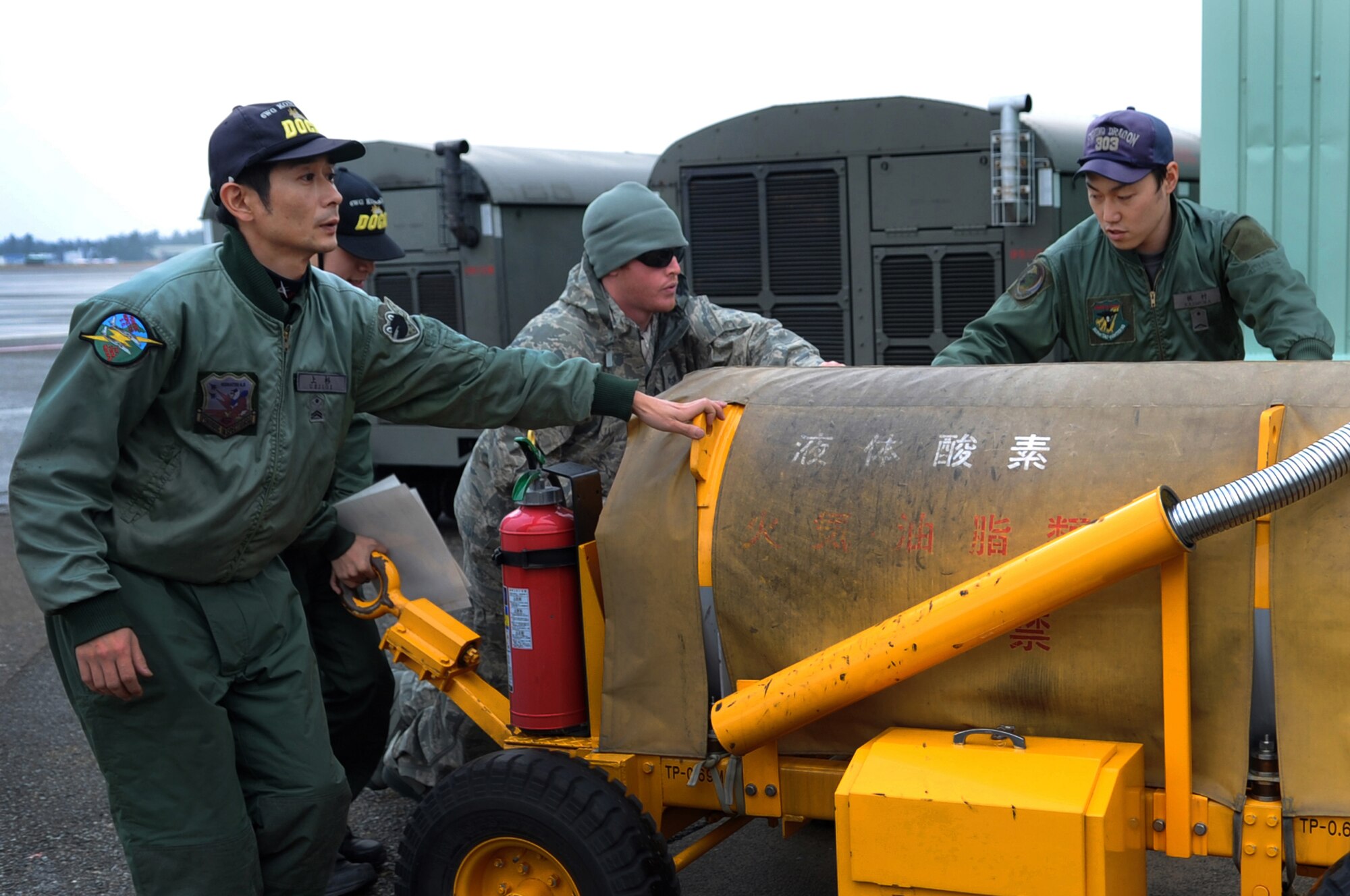 U.S. Air Force Staff Sgt. Don Wallace, 67th Fighter Squadron crew chief, helps members from the Japanese Air Self Defense Force move a lox cart as part of a week-long Aviation Training Relocation Program on Komatsu Air Base, Japan, Dec. 6, 2013. The JASDF members trained U.S. Airmen on equipment used by their Japanese counterparts in preparation for the arrival of six F-15 Eagles from Kadena Air Base. (U.S. Air Force photo by Staff Sgt. Amber E. N. Jacobs)