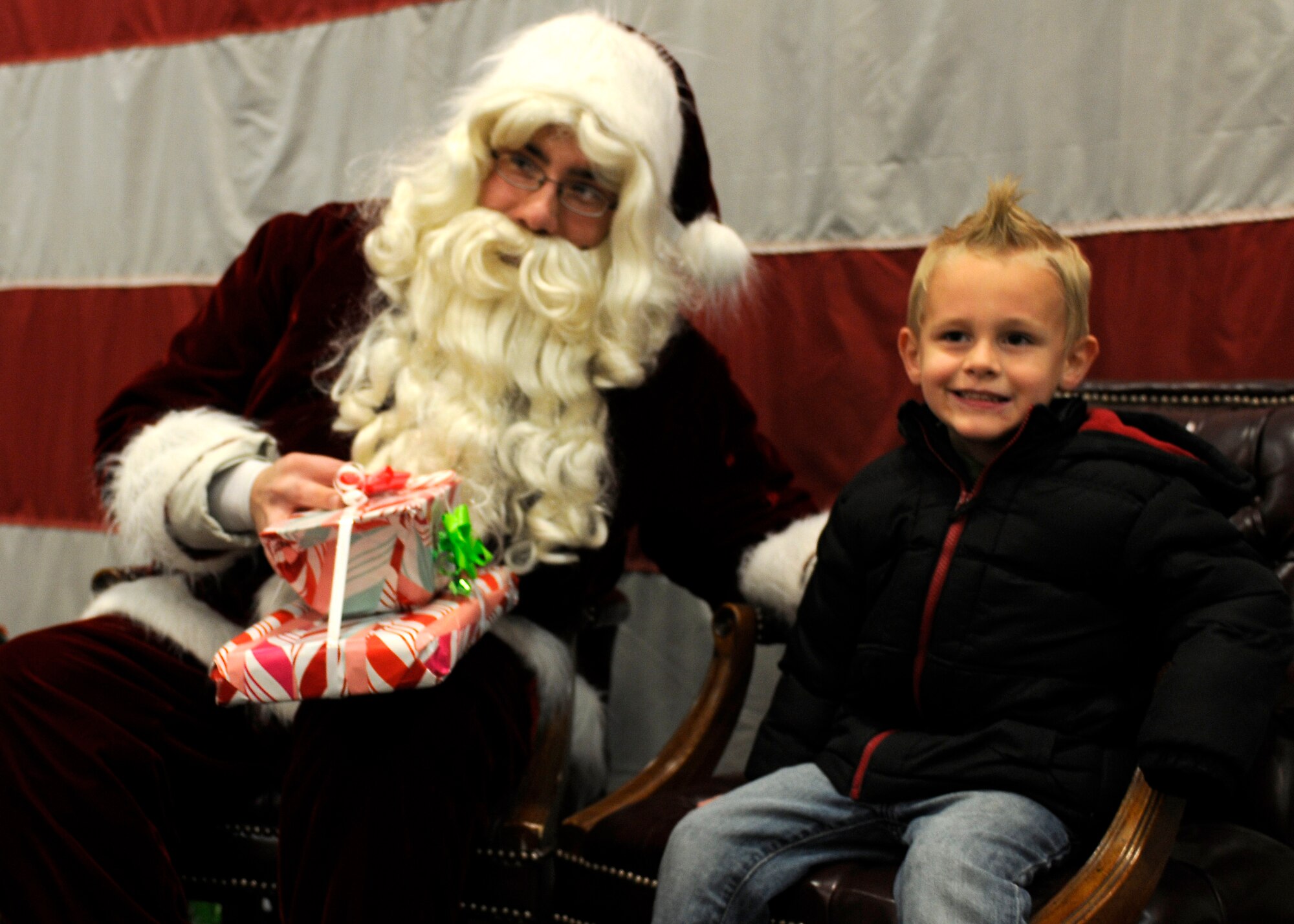 Santa Claus gives a present to Rhyder Billingsley during the 419th Fighter Wing holiday party. (U.S. Air Force photo /Senior Airman Allen Stokes)