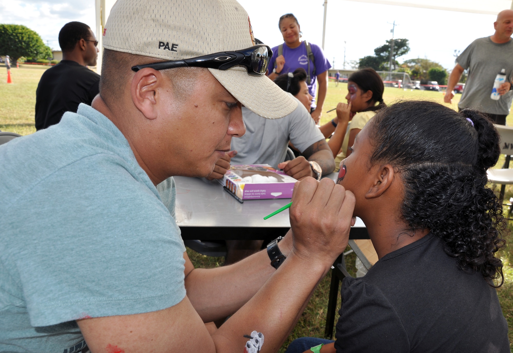 U.S. Army Chief Warrant Officer Sang Pae paints the face of a Honduran child during Joint Task Force-Bravo's "Operation Holiday Blessing" at Soto Cano Air Base, Honduras, Dec. 6, 2013. More than 200 volunteers from the Task Force worked together to host more than 300 local orphans for a holiday celebration. The orphans spent the afternoon at the base participating in several activities and even received a visit from Santa Claus. Each orphan received several gifts, all of which were donated by Joint Task Force-Bravo personnel. (U.S. Air Force photo by Capt. Zach Anderson)