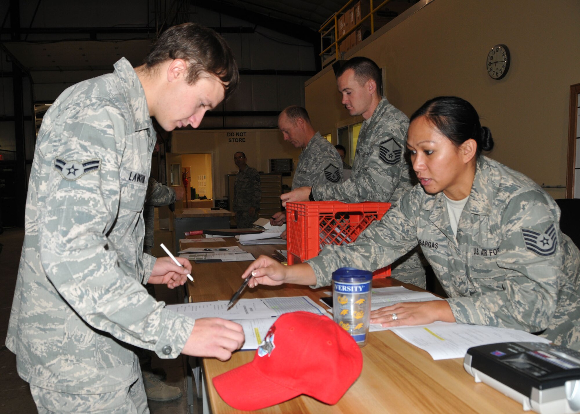 219th RED HORSE Squadron Tech. Sgt. Rhoda Bargas helps Airman 1st Class Cody Lawhon with mobility paperwork in preparation for a deployment to Colorado to support flood relief efforts on Oct. 10, 2013. (U.S. Air Force photo/Senior Master Sgt. Eric Peterson)

