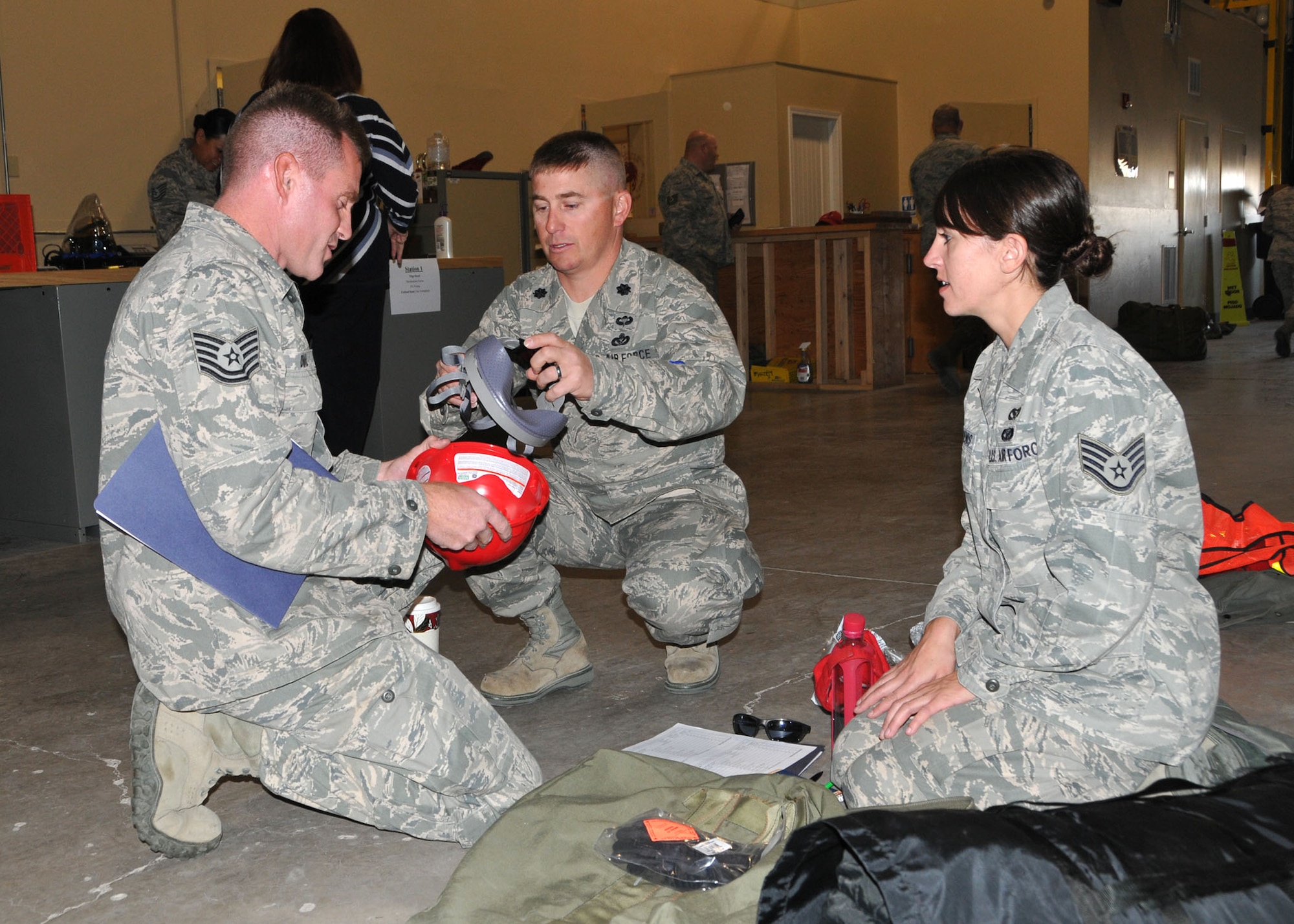 219th RED HORSE Squadron Commander Lt. Col. Rusty Vaira assists Tech. Sgt. Douglas Dial and Staff Sgt. Mary St. Denis with assembling hard hats in preparation for a deployment to Colorado to support flood relief efforts on Oct. 10, 2013. (U.S. Air Force photo/Senior Master Sgt. Eric Peterson)

