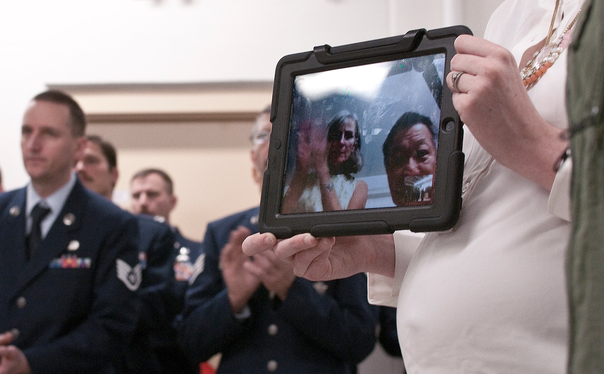 JOINT BASE ELMENDORF-RICHARDSON, Alaska -- Dawn and Toshi, parents of Major Matthew S. Komatsu, a pararescueman with the Alaska Air National Guard's 212th Rescue Squadron, watch via video chat as their son recieves the Bronze Star Medal at a ceremony here Dec. 7, 2013. Komatsu was awarded the Bronze Star Medal for his honorable service while engaged with the enemy at Camp Bastion, Afghanistan in September 2012. National Guard photo by: Tech. Sgt. Jennifer Theulen.  