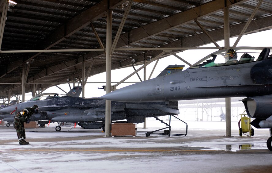 Lt. Col. Michael Thode, 419th Operations Group deputy commander, and a crew chief from the 419th Aircraft Maintenance Squadron run through pre-flight checks in chemical gear. (U.S. Air Force photo illustration/Senior Airman Alan Stolkes)