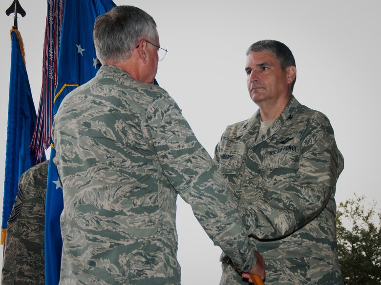 Col. James M. Phillips receives the wing guidon from Maj. Gen. George F. Williams, Air Force Special Operations Command mobilization assistant to the commander, during an assumption of command ceremony that installed him as commander of the 919th Special Operations Wing Dec.  7,  at Duke Field, Fla. (U.S. Air Force photo/Tech. Sgt. Jasmin Taylor)