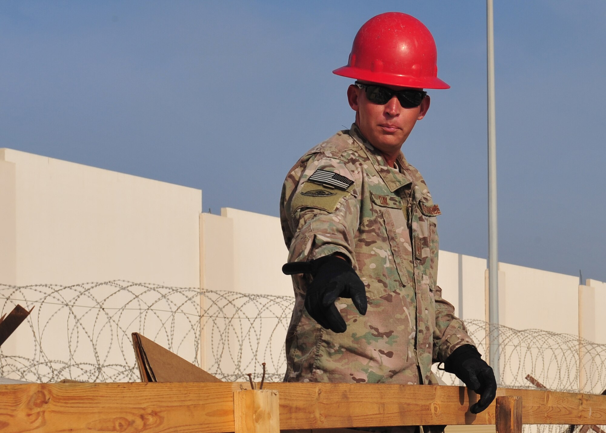 Air Force Master Sgt. Mark Day, 557th Expeditionary Rapid Engineer Deployable, Heavy Operations Repair Squadron Engineer site lead, helps to prepare building material for construction of the new fitness center at an undisclosed location in Southwest Asia, Dec. 5, 2013. RED HORSE provides a highly mobile and self-sufficient Air Force heavy repair and heavy construction capability to support contingency operations world-wide. (U.S. Air Force photo by Staff Sgt. Michael Means/Released)
