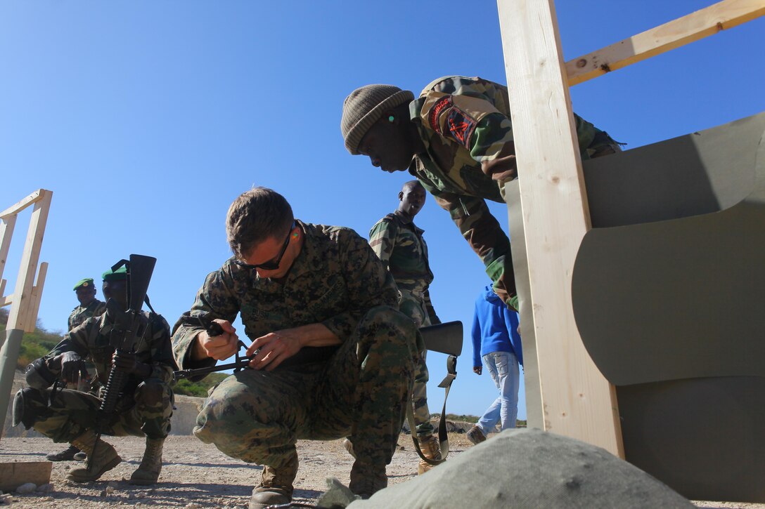 Sgt. Joshua Bush, a combat engineer with Special-Purpose Marine Air-Ground Task Force Africa 13, adjusts the front-sight post of a Senegalese Companie de Fusilier Marine Commando’s M16 while zeroing the weapon’s battle sight on the range in Thiès, Senegal, Nov. 25, 2013. During the first week of the task force’s fourth month-long engagement in Senegal this year, the Marines focused on basic and combat marksmanship skills.