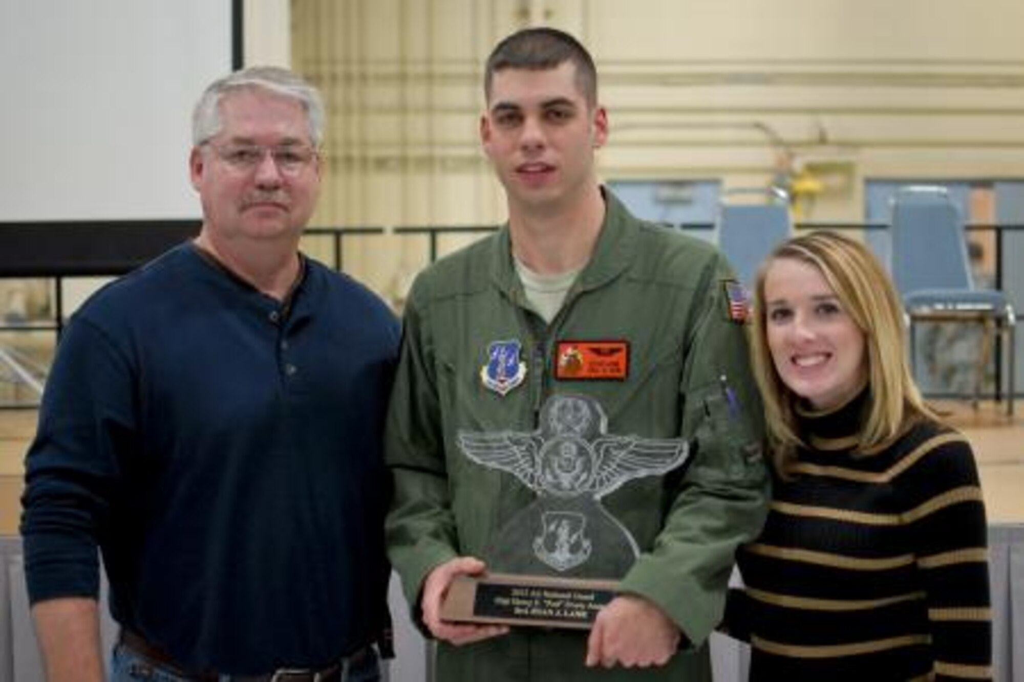 Senior Airman Ryan J. Lane of the 169th Airlift Squadron, center, displays his Red Erwin award with family members Dec. 8, 2013, at the 182nd Airlift Wing, Peoria, Ill. Lane competed against 3,000 other Air National Guard candidates to earn the Staff Sgt. Henry E. "Red" Erwin Outstanding Enlisted Aircrew Member Airman of the Year Award. He was presented the honor for his outstanding accomplishments, leadership traits that impacted his unit's mission and self-improvement in areas such as education and training. (U.S. Air National Guard photo/Staff Sgt. Lealan C. Buehrer)  