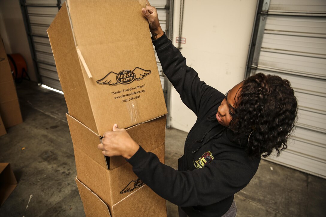 Sergeant Eleanor Peden, embark noncommissioned officer, 15th Marine Expeditionary Unit, organizes boxes during a volunteer event at The Angel's Depot in Vista, Calif., Dec. 6. All donations go to improving the quality of life for senior citizens. Peden, 25, is from New York. (U.S. Marine Corps photo by Cpl. Emmanuel Ramos/Released)
