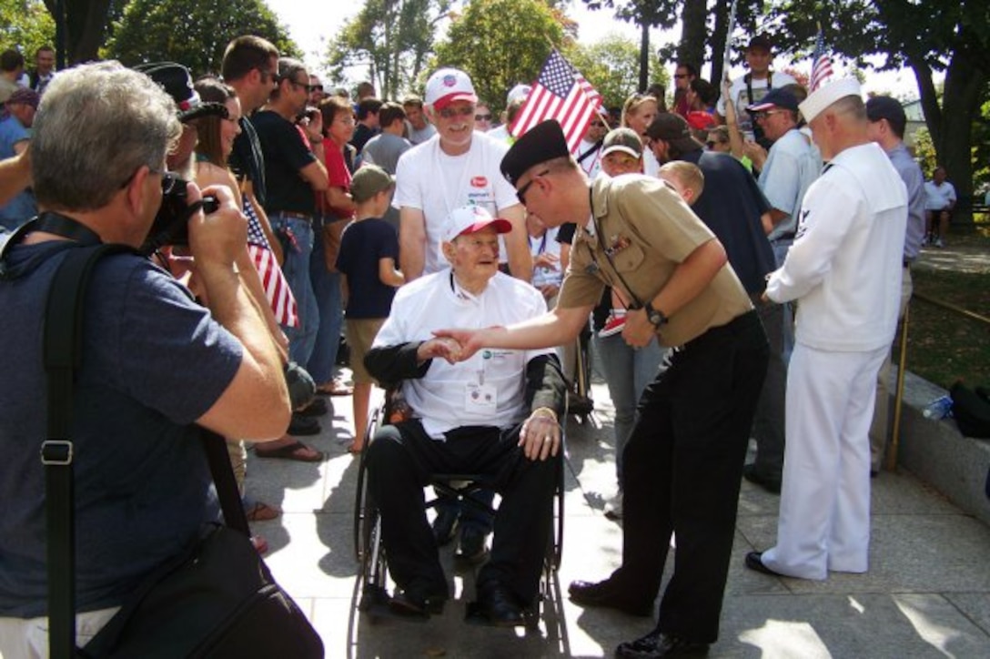 A Marine thanks Charles Gray for his military service as he heads to the World War II Memorial.