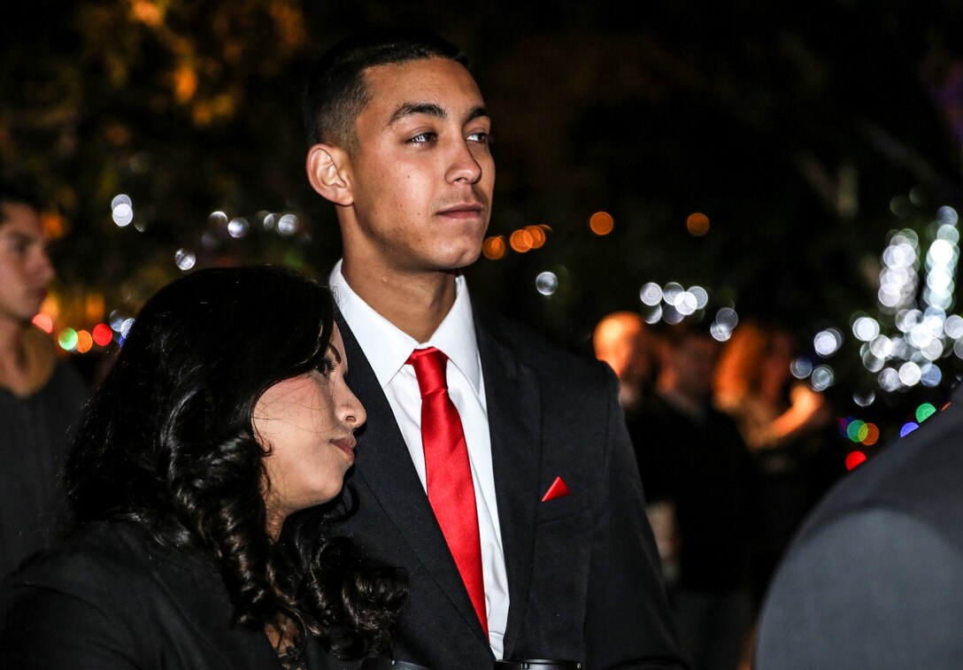 Lance Cpl. Julio Rodriguez, field wireman, 15th Marine Expeditionary Unit, and his date Jenny Caballero, listen to Lt. Col. John R. O’Neal, commanding officer, 15th MEU, during the unit’s holiday party at the San Diego Botanical Gardens in Encinitas, Calif., Dec. 6. During the party, families enjoyed food, Santa and an ugly sweater contest. Rodriguez, 21, is from Springfield, Mass. (U.S. Marine Corps photo by Cpl. Emmanuel Ramos)
