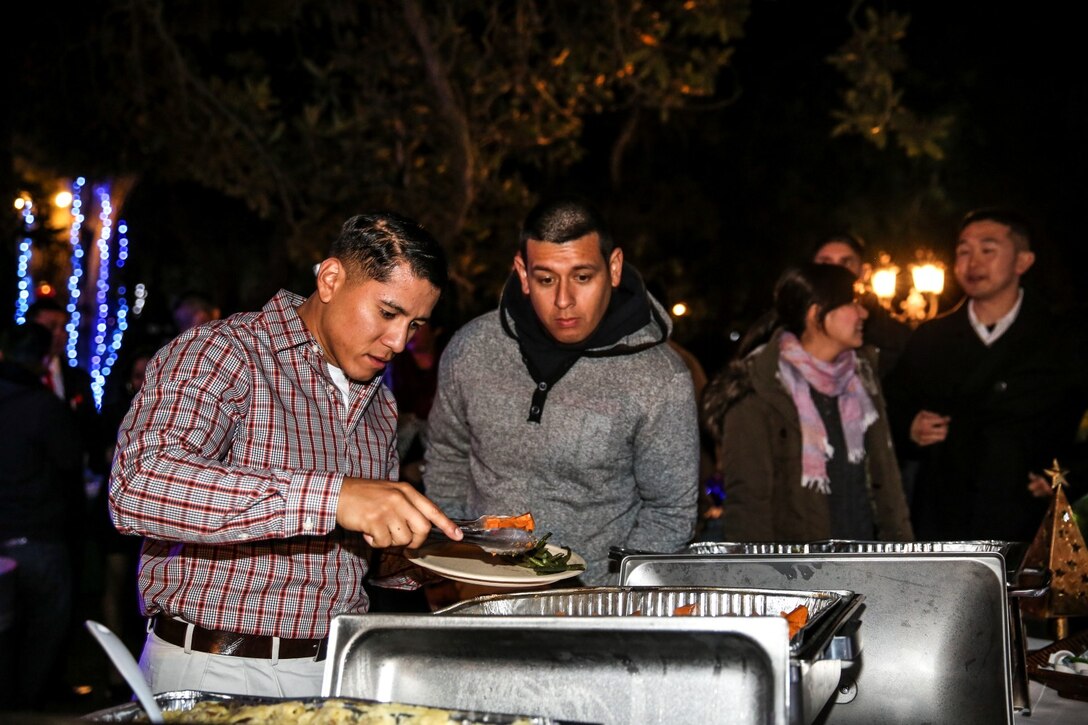 Corporal Jacob Martinez, left, and Cpl. Albert Perez III, both administration specialists, 15th Marine Expeditionary Unit, serve themselves food during the unit’s holiday party at the San Diego Botanical Gardens in Encinitas, Calif., Dec. 6. During the party, families enjoyed food, Santa and an ugly sweater contest. Martinez, 24, is from Houston. Perez, 21, is from Los Angeles. (U.S. Marine Corps photo by Cpl. Emmanuel Ramos)