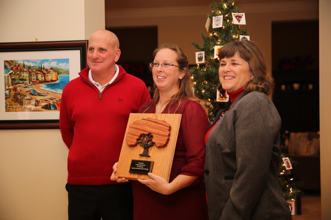 Tiffani Straw, center, recipient of the Bonnie Amos Award stands with Maj. Gen. Steven Busby, left, commanding general of 3rd Marine Aircraft Wing (MAW) and a family readiness officer after receiving her award aboard Marine Corps Air Station Miramar, Calif., Dec. 6. Straw was the first Committed and Engaged Spouse of the Year to be awarded.