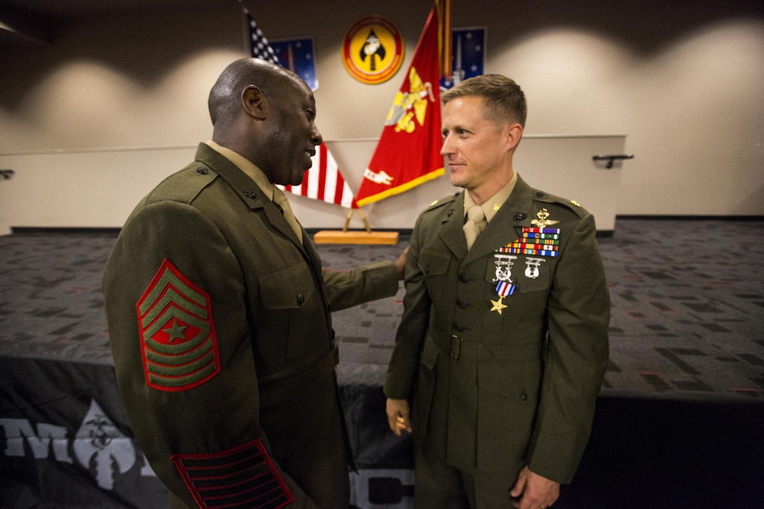 Sgt. Maj. Ronald L. Green congratulates Maj. Robb McDonald after the ceremony honoring McDonald for his actions while deployed to Camp Bastion, Afghanistan. McDonald receives the Silver Star, the nation’s third-highest combat valor award, for his role in repelling an enemy attack inside Camp Bastion, Afghanistan. McDonald was serving as the executive officer of Marine Attack Squadron 211, III Marine Aircraft Wing. The ceremony took place at the 1st Marine Special Operations Battalion command building at Camp Pendleton Dec. 9. 

According to the award citation on Sept. 14, 2012 15 insurgents infiltrated Camp Bastion and attacked the coalition forces stationed there. McDonald took charge after the commanding officer, Lt. Col. Christopher Raible, was mortally wounded. He risked his life to lead Marines away from a building that could have become a death trap had the troops remained there. He later shot and killed one attacker and directed two helicopter attacks that killed several other insurgents.