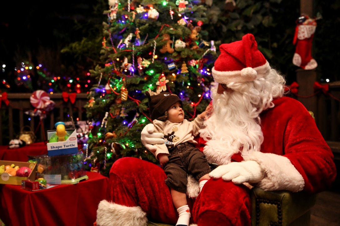 A child sits with Santa Claus during the 15th Marine Expeditionary Unit’s holiday party at the San Diego Botanical Gardens in Encinitas, Calif., Dec. 6. During the party, families enjoyed food, Santa and an ugly sweater contest. (U.S. Marine Corps photo by Cpl. Emmanuel Ramos)